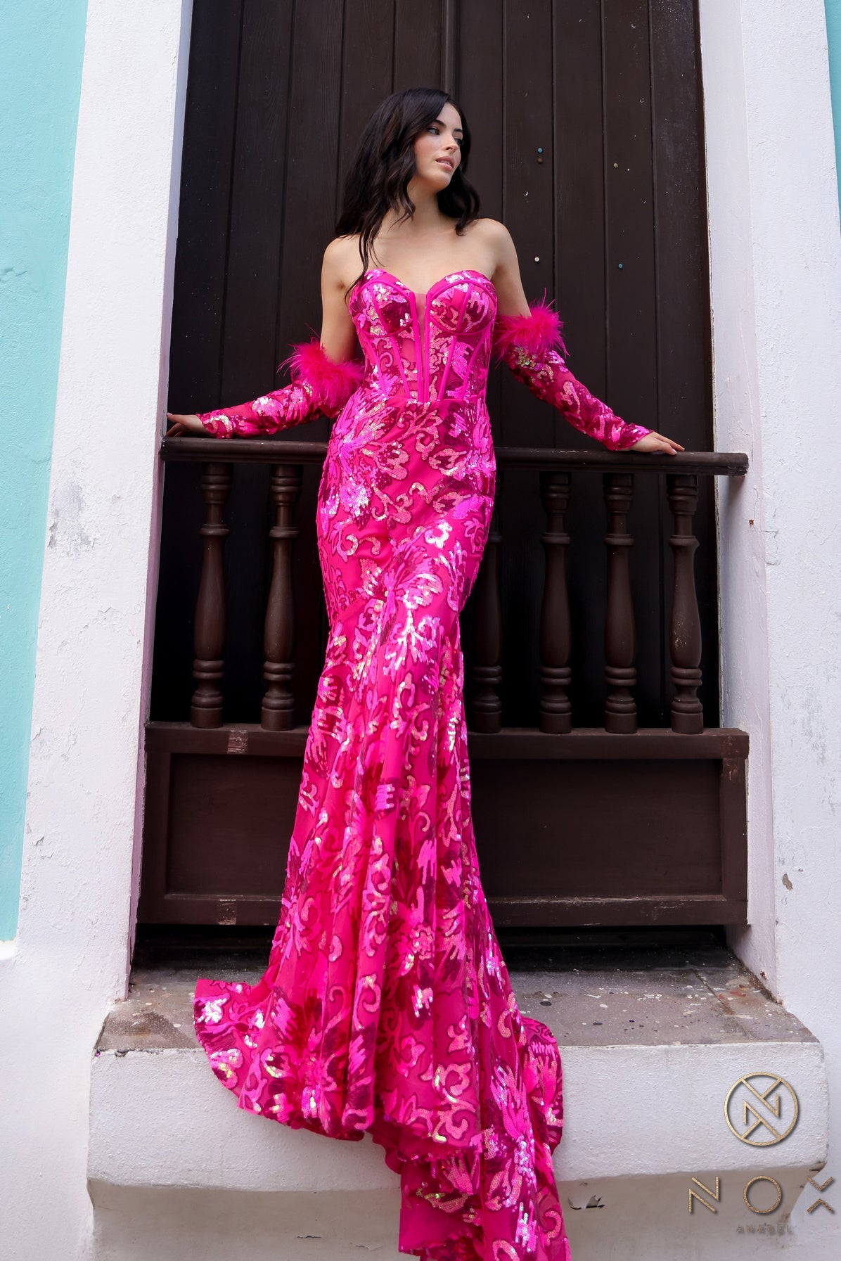 Step into the spotlight in the stunning Nox Anabel D1269 Sequin Mermaid Long Sleeve Prom Dress. With a flattering feather corset and intricate sequin detailing, this formal gown will make you feel like a star. Perfect for prom or any special event, stand out in style with this elegant and unique dress. Sizes: 0-16 Colors: Emerald, Fuchsia, Orange, Turquoise, White/Multi