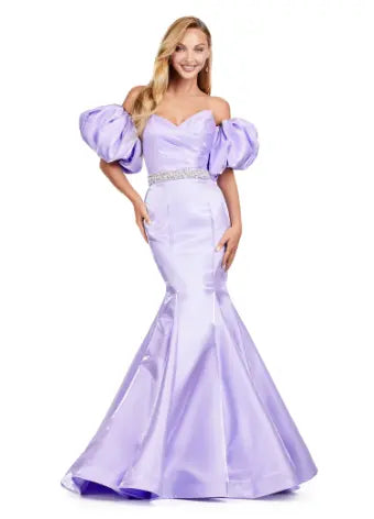 Expertly crafted by Ashley Lauren, this 11419 Long Prom Dress boasts a stunning mermaid silhouette with a strapless design and luxurious satin fabric. The oversized puff sleeves add a bold and elegant touch, making you stand out at any formal event or pageant. Elevate your look with this timeless and sophisticated gown. Voluminous puff sleeves and a classic sweetheart neckline frame this stunning gown. With its mermaid fit and jeweled belt, this gown is a dream come true!