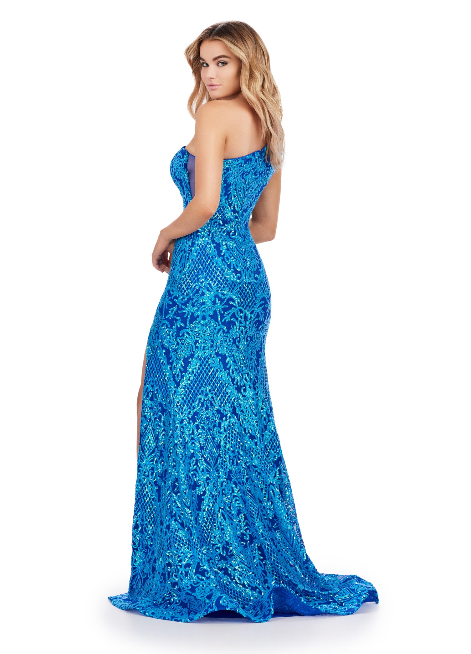 The Ashley Lauren 11471 Long Prom Dress is expertly crafted with a fitted one shoulder design and stretch sequin material, creating a stunning formal pageant gown. Stand out with its sleek silhouette and comfortable fit, perfect for your next special occasion. This memorable one shoulder stretch sequin gown features an illusion cut out side and left leg slit.