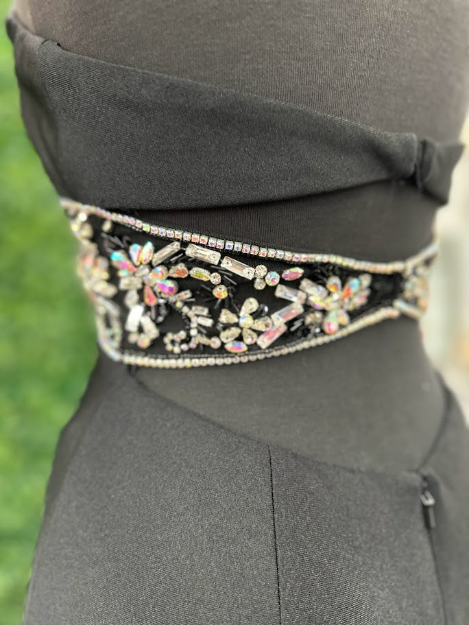 This Johnathan Kayne gown in size 4 features a sleek black fitted silhouette that elegantly contours the body. The high slit adds a dramatic touch, while the cut-out back offers a modern, alluring detail. Accentuated with a crystal-embellished waist, this prom dress combines sophistication with a hint of sparkle, perfect for making a confident statement at any formal event.
Size: 4
Color: Black