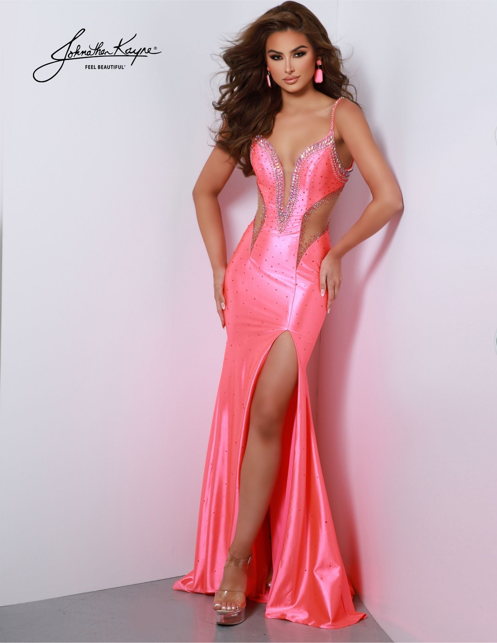 Experience the sophistication of Johnathan Kayne 2882 Prom Dress. The stunning fitted dress features a low V-neckline and crystals, with a train and slit for a sleek silhouette. Perfect for formal events, pageants, and more. Dare to stun and make a statement with our shiny 4-Way Lycra dress. Featuring edgy side cutouts, a low V-neckline, and a dramatic slit, this dress is your invitation to stop traffic with your unique and captivating style.