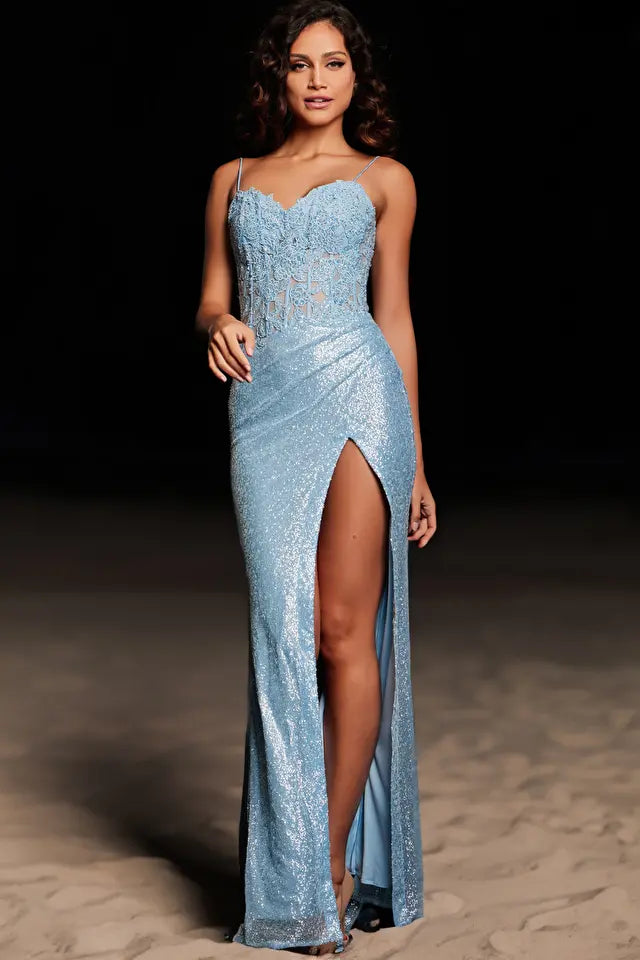 The Jovani 37649 prom dress is a show-stopping and elegant choice for a memorable evening. This form-fitting floor-length gown is designed to accentuate the curves with a sleek and sophisticated silhouette. The dress features a high slit, adding a touch of allure and allowing for graceful movement, while a train adds an element of glamour and drama.  The sheer bodice is crafted in a corset style, adorned with intricate embroidery and heat-set stones, creating a dazzling and luxurious effect. 