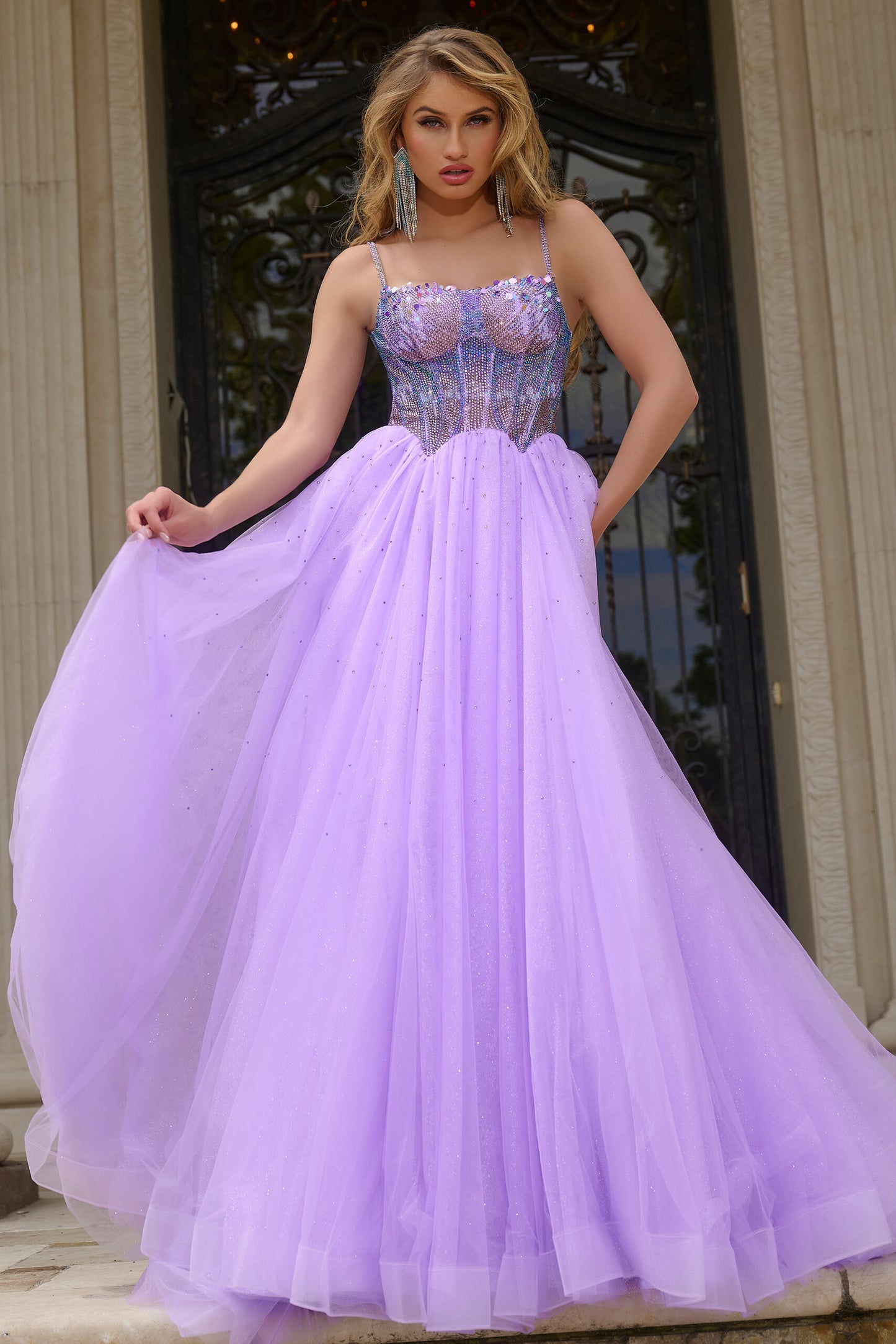 Indulge in luxury with the Jovani 44511 prom dress. Dazzling crystal bodice, A-line silhouette and shimmering sequins create a glamorous look. The scoop neck adds an elegant touch while the tulle and formal design elevate the style. Perfect for prom or pageants. Step into elegance with this exquisite ball gown, featuring a fitted beaded corset bodice that shimmers with intricate details.