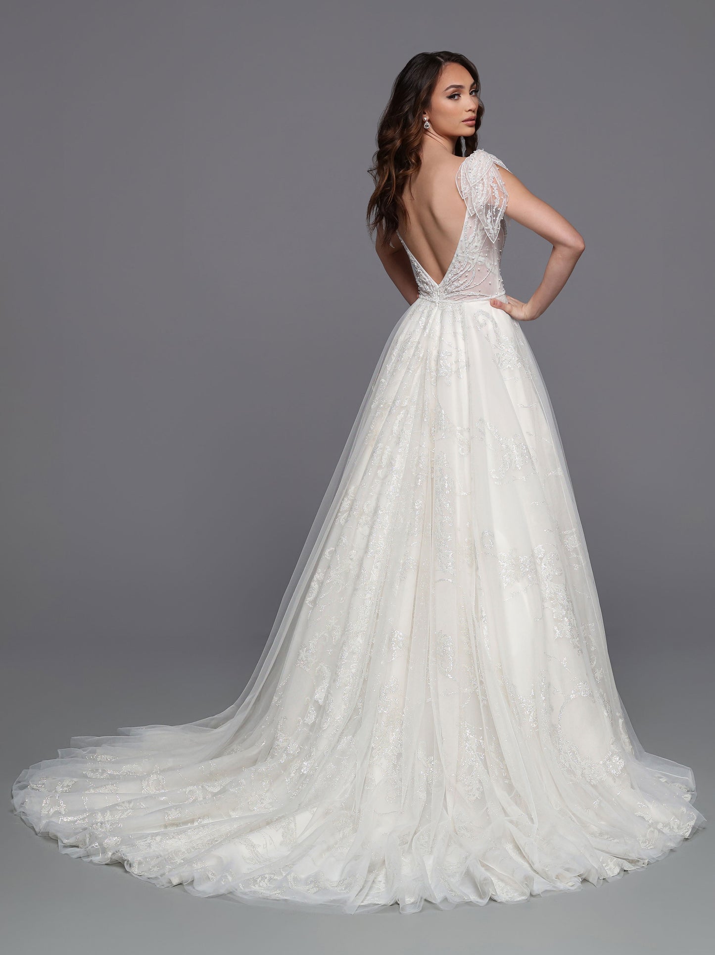 This Davinci Bridal 50718 Long Glitter Beaded Wedding Ballgown Dress is sure to make any bride sparkle. The A-line silhouette features embroidered patterned lace coupled with a beaded tulip-style cap sleeve, creating a sheer yet elegant fairytale look. The layers of tulle combine for an unforgettable wedding dress. Sizes: 2-20 Colors: Ivory