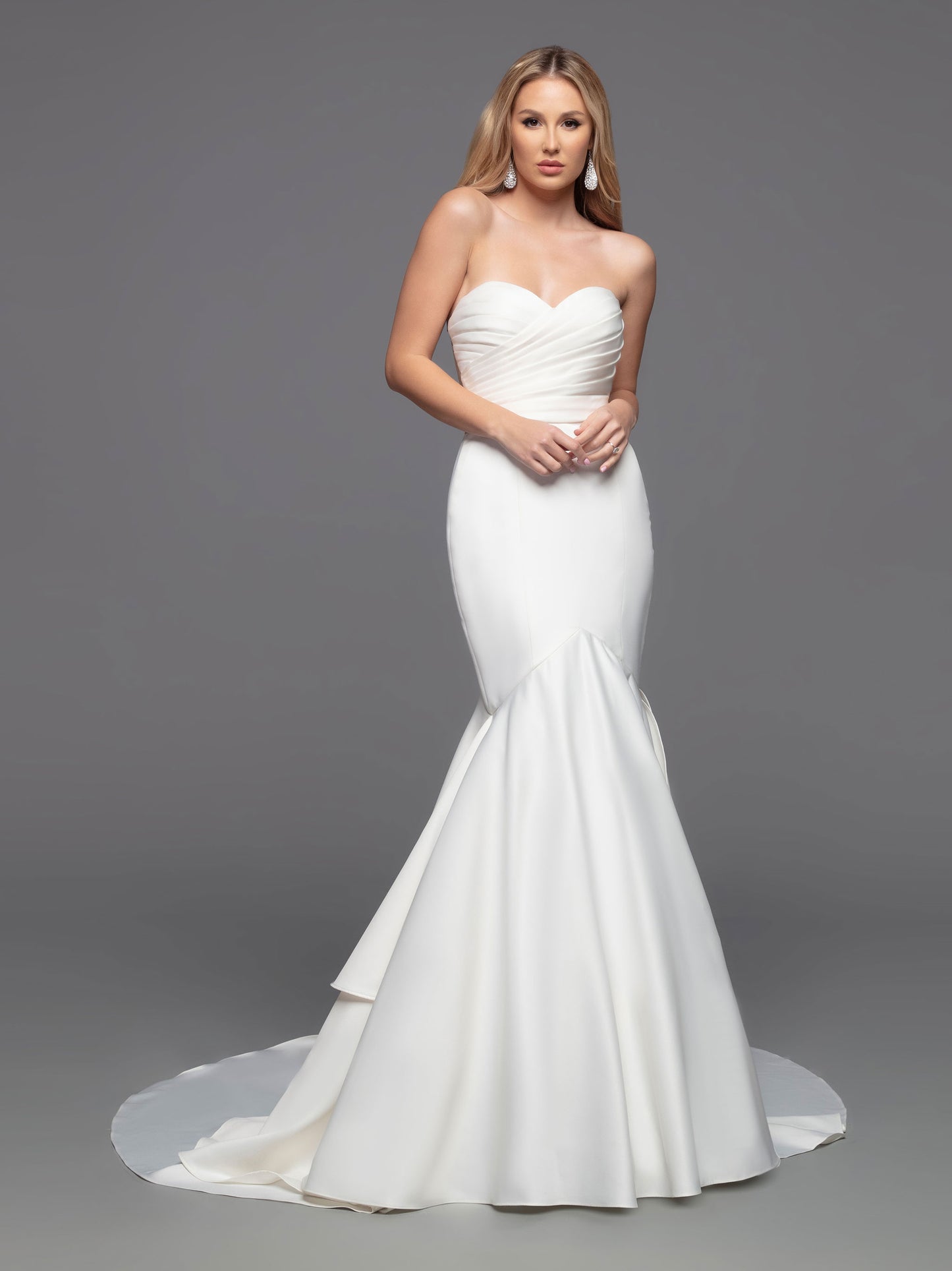 The Davinci Bridal 50808 Long fitted Strapless satin mermaid wedding dress boasts a beautiful modern design with a traditional flair. Its fit & flare silhouette is enhanced by an opaque ruched front bodice and a romantic ruffled mermaid skirt with a sheer back bodice. This stylish design is finished with covered buttons and a tiered back skirt, culminating in a chapel train. Sizes: 2-20 Colors: Ivory, White