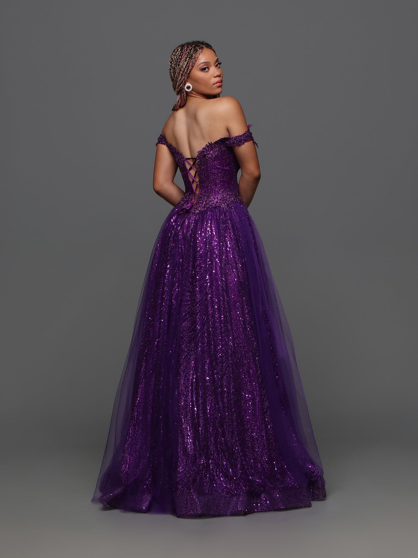 The Candice Wang 72405 A Line Glitter Tulle Lace Prom Dress features an off the shoulder design and a corset for a stunningly elegant look. The A-line shape, glitter tulle, and intricate lace details add a touch of glamour to this formal gown. Perfect for any special occasion. Sizes: 0-20 Colors: Purple