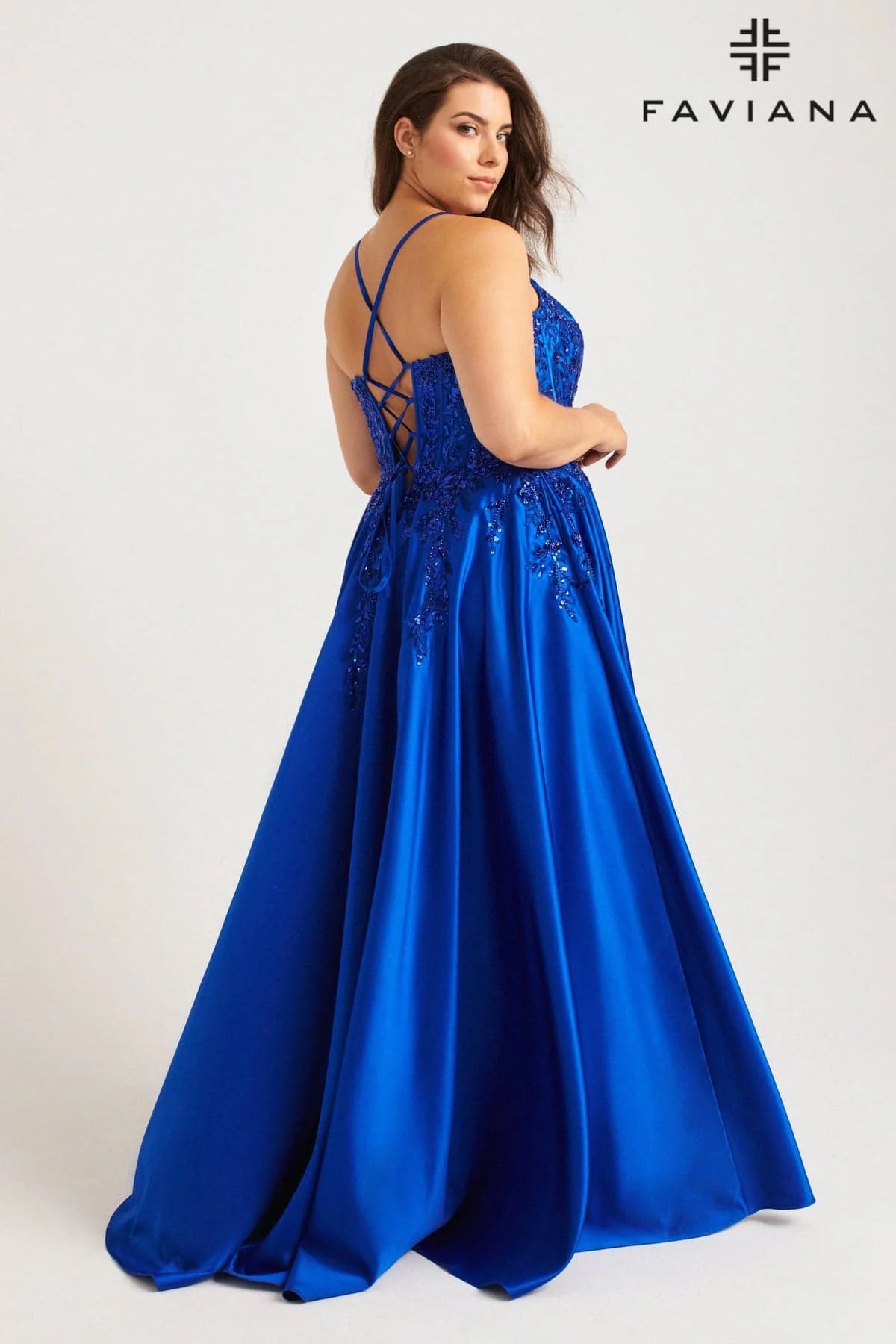 Turn heads with the Faviana 9575, a bold plus-size prom gown designed to captivate. This royal satin dress features a structured corset top adorned with shimmering sequins and delicate lace, accentuating your curves with confidence. Functional pockets add modern ease without sacrificing glamour, making it perfect for those who dare to shine all night. Step into this statement piece and own every moment of your formal occasion.
Size: 20W
Color: Royal