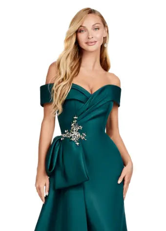 This Ashley Lauren 11425 Long Evening Dress is the perfect choice for any formal occasion. The off-shoulder design adds a touch of elegance, while the fitted satin fabric hugs your figure for a flattering silhouette. The overskirt adds a dramatic flare, making you feel like a pageant queen. Elevate your style with this versatile and stunning dress. An elegant off the shoulder neckline drapes the shoulders in elegant evening gown. The look is complete with beaded details and a side overskirt.