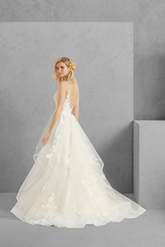 Flirty, feminine and fit for a princess, Sweet is a ball gown made from cascading layers of butterfly lace on tulle, with a horsehair trim for added volume. A dramatic V-shaped back is framed by illusion straps framing a V-neck in the front as well. The natural waist is accented by a Duchess satin belt, which is accented by several satin buttons in the back. Sizes: 2,4,6,8,10,12,14,16,18,20,22,24,26,28 Color: LCCLI