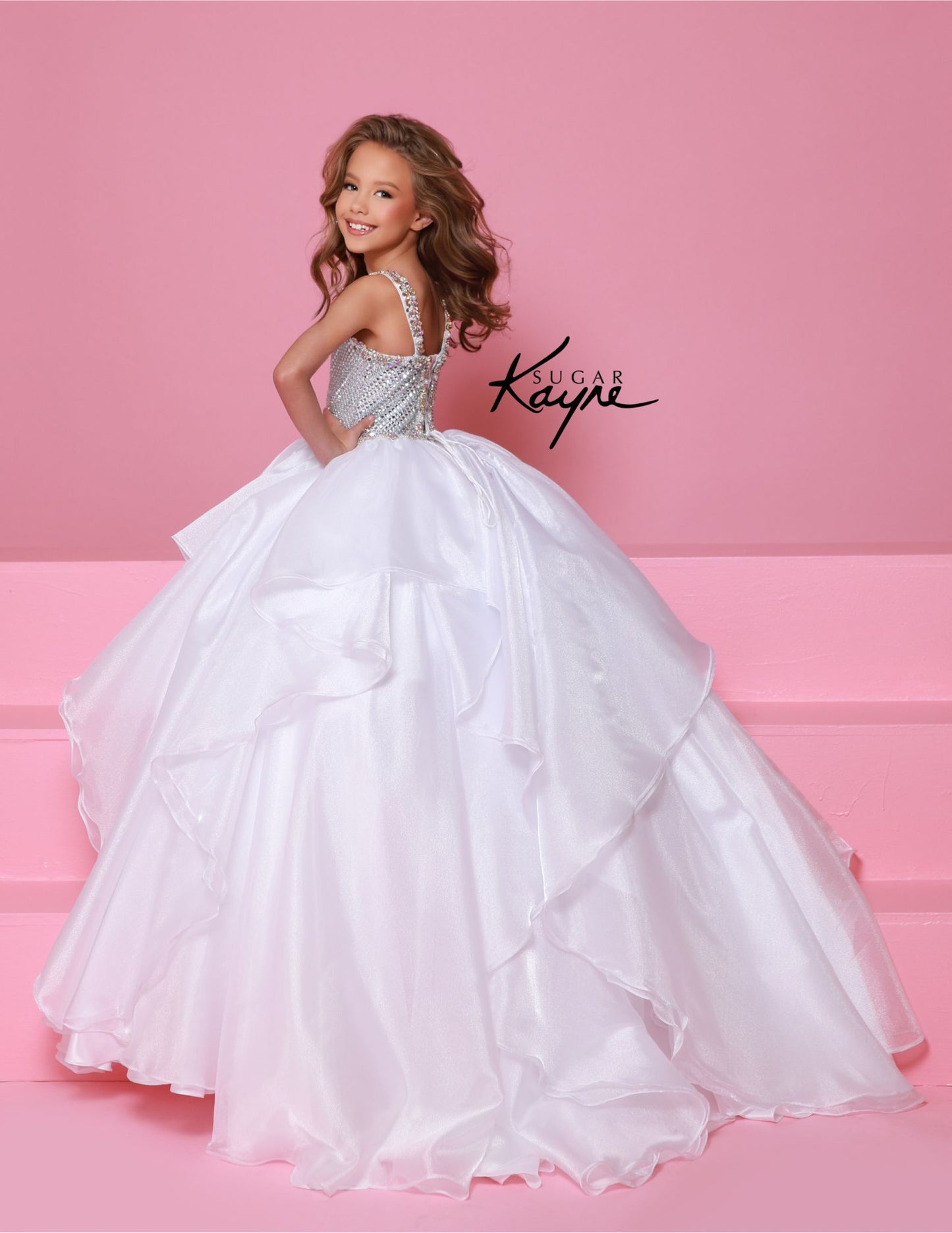 Step onto the pageant stage with confidence in the Sugar Kayne C383 Girls Pageant Dress. This stunning ballgown features a crystal bodice that will shimmer and shine under the lights, while the ruffle detail adds a touch of playful elegance. The layered skirt adds volume and movement, making you the star of the show. Make a dramatic statement at your next pageant with this stunning diamond mesh dress. The ruffled shimmer organza skirt completes the look, offering a perfect blend of elegance and flair.
Size