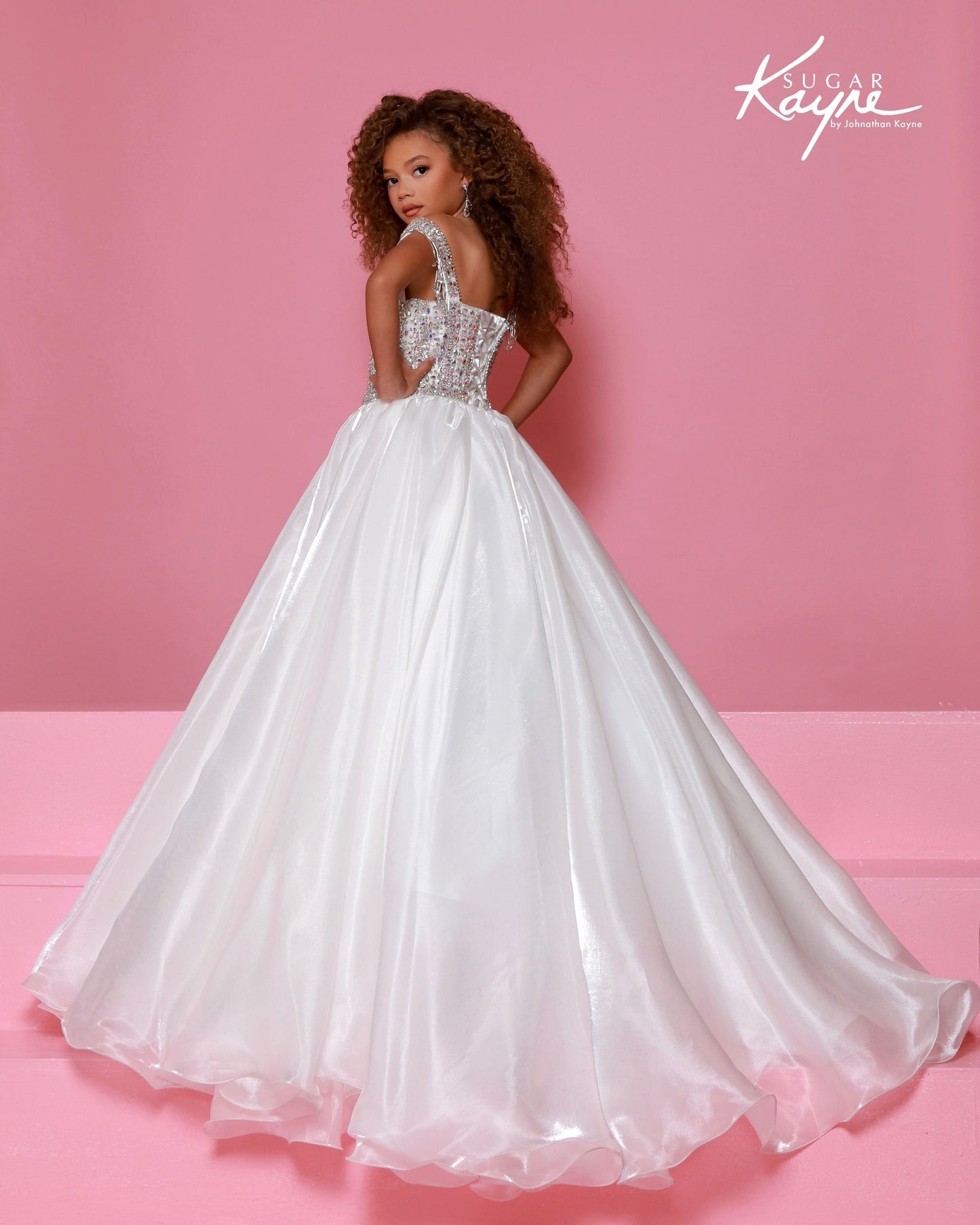 Designer: Sugar Kayne — Style C400
This glamorous Sugar Kayne girls pageant dress in style C400 features luminous mirror organza layered over soft satin lining, creating stunning shine and movement under the lights. The full skirt flows beautifully across the stage, while the bodice is designed to give a polished, elegant shape that photographs beautifully and stands out with every twirl.
Sizes: 2–16
Colors: Bubblegum, Cherry, White