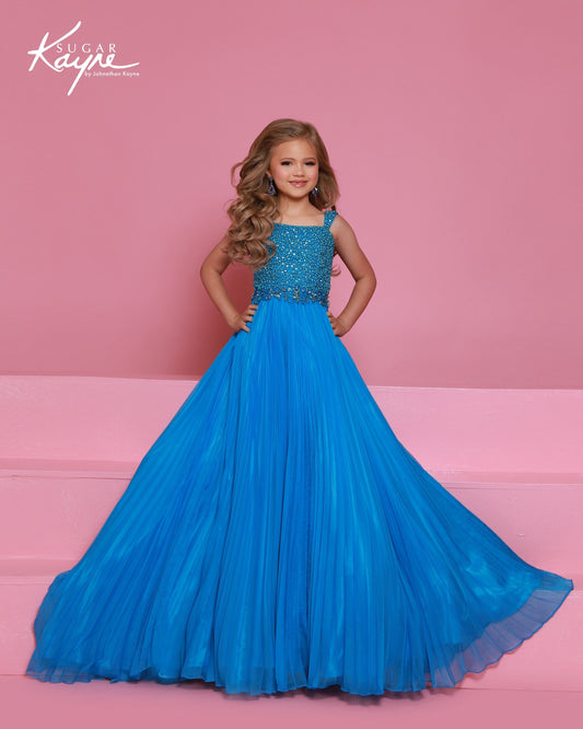 Designer: Sugar Kayne — Style C408
This lightweight Sugar Kayne girls pageant dress, style C408, showcases flowing chiffon over a satin lining for effortless drape and motion. The look is soft, feminine, and comfortable, giving her a confident presence from interview to evening wear on the pageant stage.
Sizes: 2–16
Colors: Hot Pink, Turquoise, White