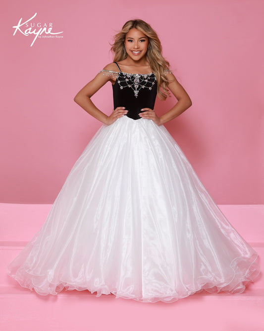 Designer: Sugar Kayne — Style C412
Elegant and rich, Sugar Kayne style C412 is a girls pageant dress that blends luxurious stretch velvet with flowing skirt details. The gown offers comfortable stretch while maintaining a refined, high-end look that stands out in formal and pageant settings.
Sizes: 2–16
Colors: Black/Pink, Black/White, White