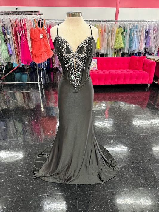 Indulge in the ultimate luxury with the Jovani D5054 Fitted backless satin prom dress. Featuring a crystal bow bodice and formal evening gown design, this dress exudes sophistication and elegance. The fitted silhouette accentuates your curves while the backless design adds a touch of sensuality. Make a statement at your next event with this exclusive piece. Experience elegance in this captivating gown featuring a floor-length silhouette that gracefully glides with every step. The dress boasts an illusion sw