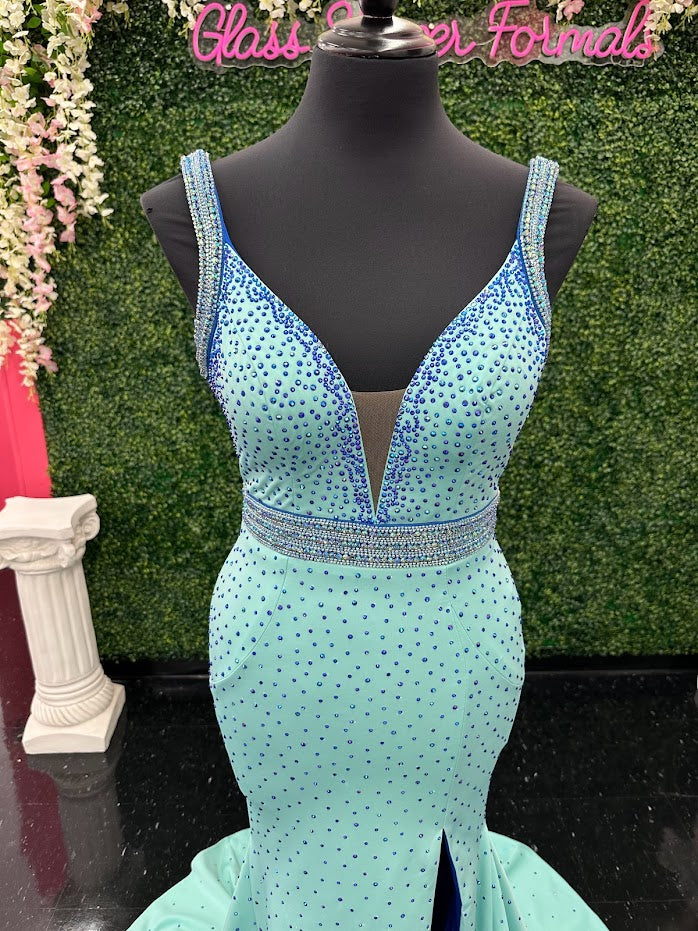 The Johnathan Kayne 2628 is a glamorous pageant dress, crafted from fitted scuba for a sleek and form-flattering effect. The gown features a crystal accented waist line, shoulder straps and v neckline with scattered crystals and glittering accents, making it perfect for special occasions. With its comfortable fit and elegant design, this size 4 dress adds sparkle to any ensemble. Color Block Combo. *Theses are ONE OF A KIND! Size: 4 Color: Aqua/Royal