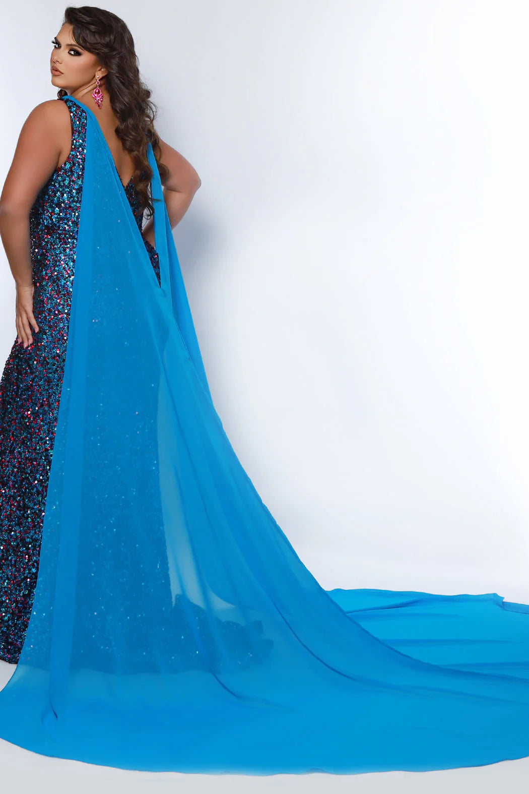 This Sydneys Closet JK2407 Long Fitted Plus Size Sequin Cape Pageant Dress Formal Gown is perfect for formal occasions. Crafted from high-quality materials, this dress features stunning sequin detailing, a long cape-style skirt, and a fitted silhouette, making it a sophisticated choice for any event. With its stylish and timeless design, this gown is sure to make a lasting impression. 