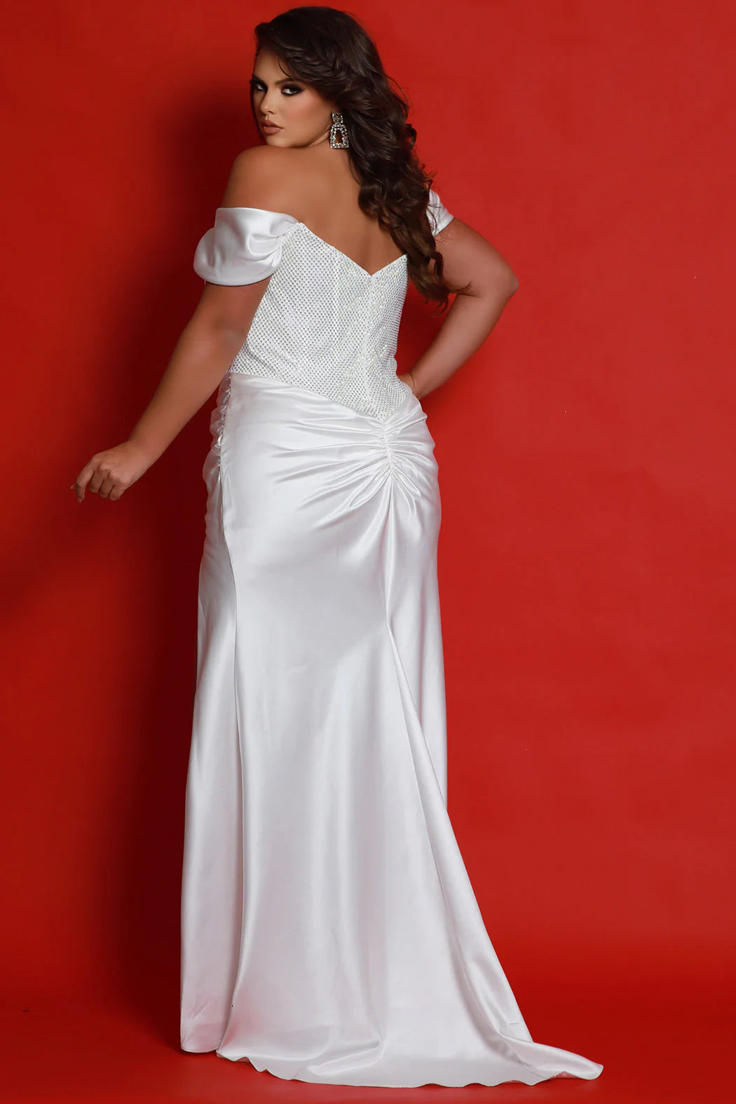 Look gorgeous in Sydneys Closet JK2417 Prom Dress. This stunning fitted maxi dress features an off-shoulder neckline, corset bodice with satin cape detail, and a thigh-high slit for a modern and sleek look. Ideal for proms, pageants, and other special occasions. Plus size available. Our showstopping Grand Marshal plus size pageant gown shines under the spotlight with a very trendy glitter corset top. 