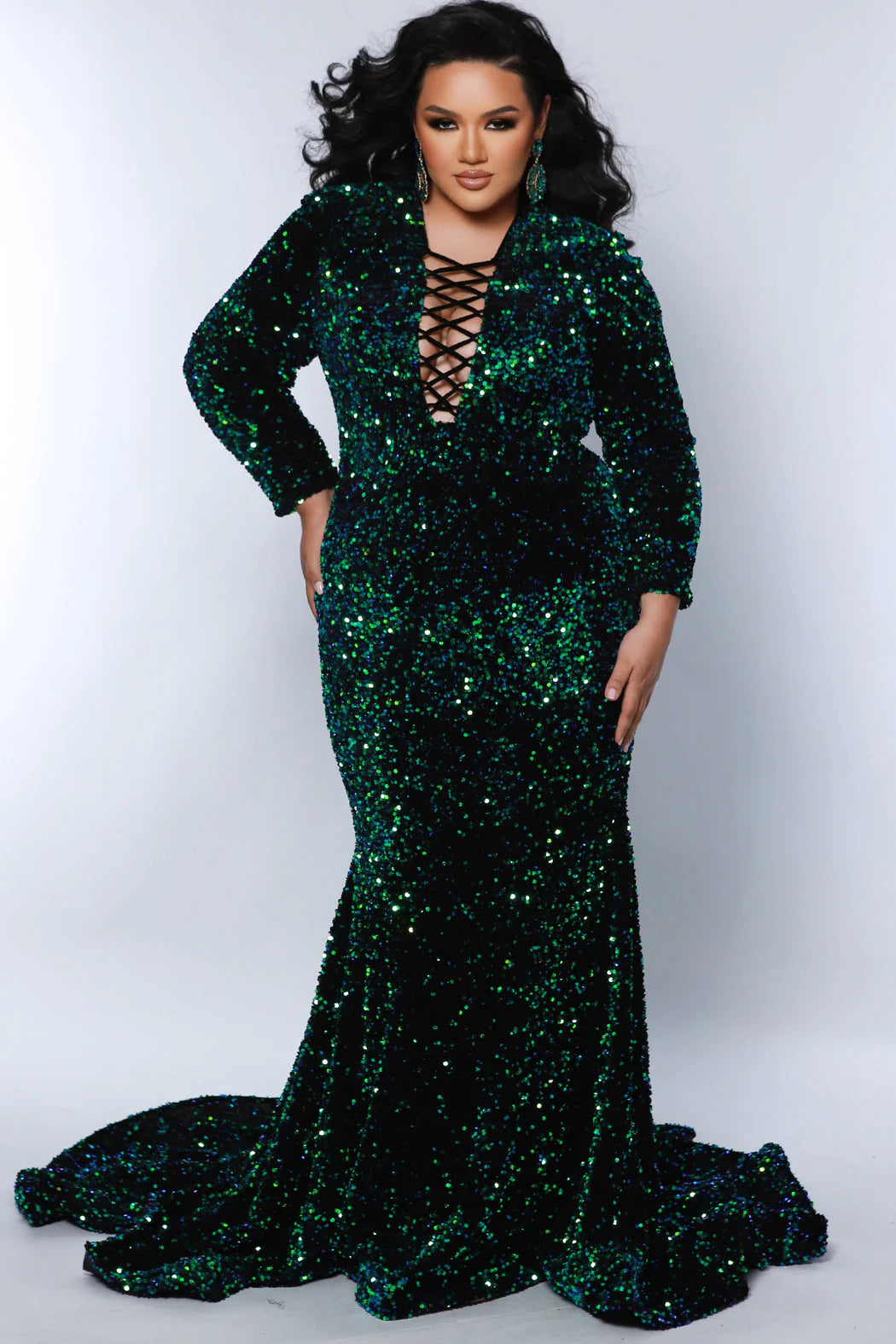 This Sydneys Closet dress is perfect for special occasions. It features a figure-hugging mermaid silhouette, a train, and a V-neckline with long sleeves. The fabric is a luxurious blend of sequin and velvet for a stunning look. The corset ensures a perfect fit for plus size wearers. Our Clutch plus size sequin Mermaid gown guarantees you'll dazzle everyone at a Pageant, Prom 2024 or any black-tie event.