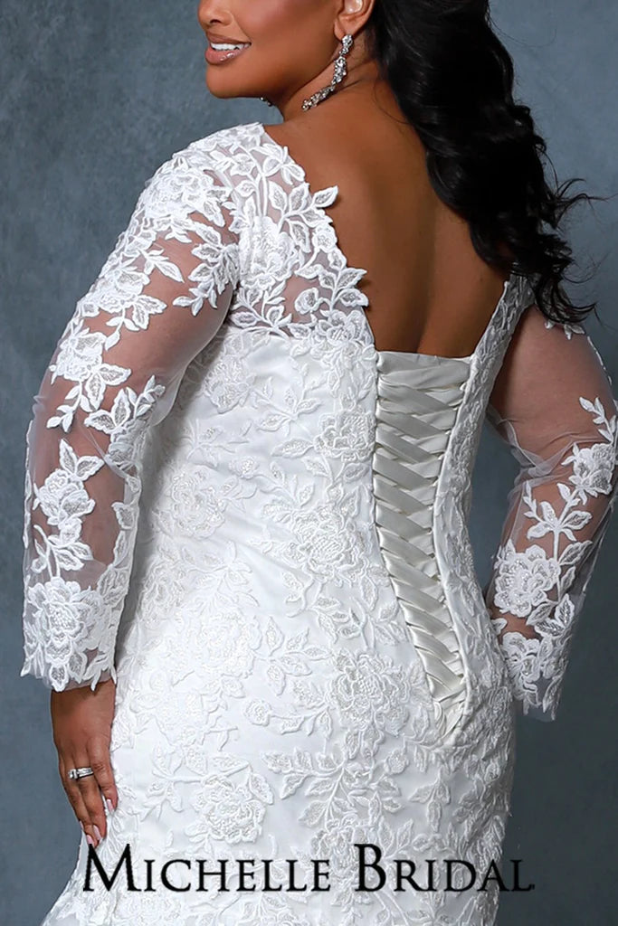 Michelle Bridal For Sydney's Closet MB2202 Fitted Silhouette V-Neck Sleeves With Appliques And Illusion Mesh Embroidered Lace With Tone On Tone Sequin Floral Appliques With Rose Pattern Plus Size "Bridgette" Bridal Gown. The sophisticated Michelle Bridal For Sydney's Closet MB2202 is a stunning plus size "Bridgette" bridal gown featuring a fitted silhouette with V-neck sleeves, appliques, and embroidered lace with sequin floral appliques and a rose pattern.