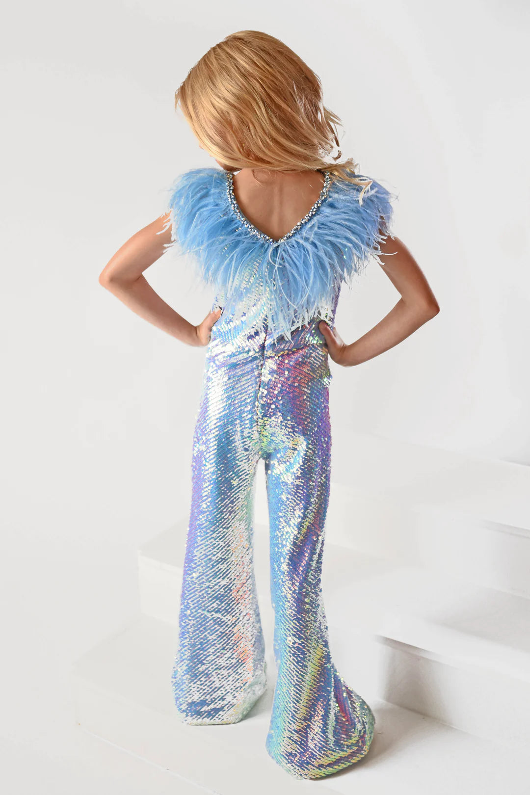 Ava Presley 38046 Long Sequin Jumpsuit is a delightfully fun fashion choice for girls. The detachable capes and feather bodice add playful panache for a statement-making look. The perfect pick for any occasion. Sizes: 2-16 Colors: Red, Purple, White, Powder Blue