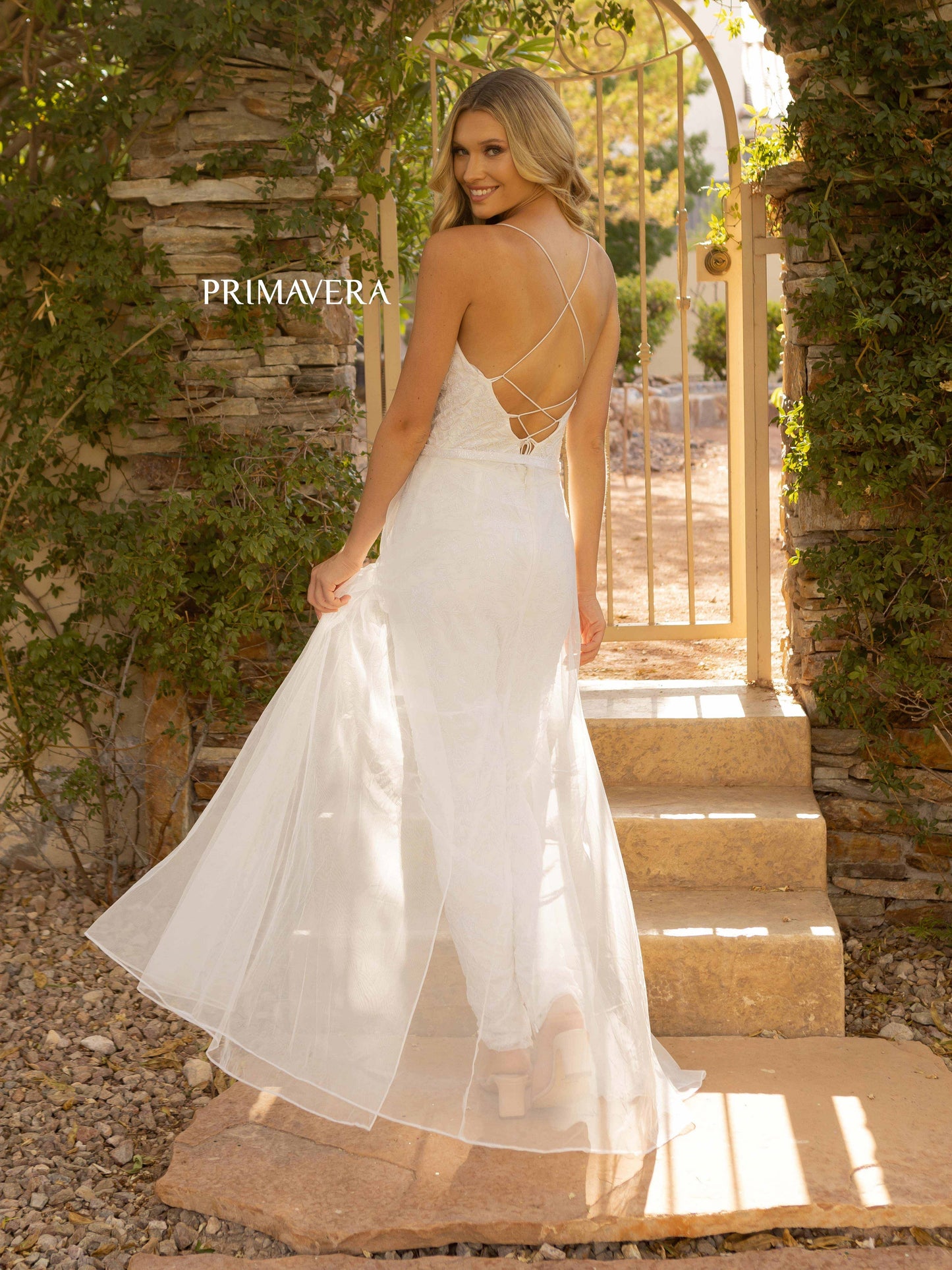 Primavera Couture 3973 Long Beaded Prom Jumpsuit featuring a detachable beaded belt tulle Overskirt. This Backless Jump suit features a Corset Great for Pageants! Sizes: 000-24 Colors: Ivory, Rose, Royal Blue
