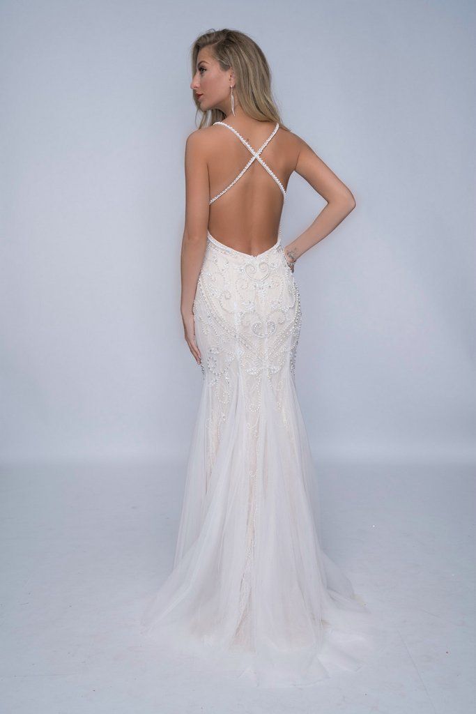 Nina Canacci 4181 is a fully embellished & Beaded long Ivory & Nude Formal Evening Gown, Wedding Dress, Prom Dress & Bridal. This Backless gown features fully beaded straps with a lace underlay bodice with crystal rhinestone embellishments and beading leading to a slight trumpet tulle mermaid skirt. Available Sizes: 12 Available Colors: Ivory/Nude