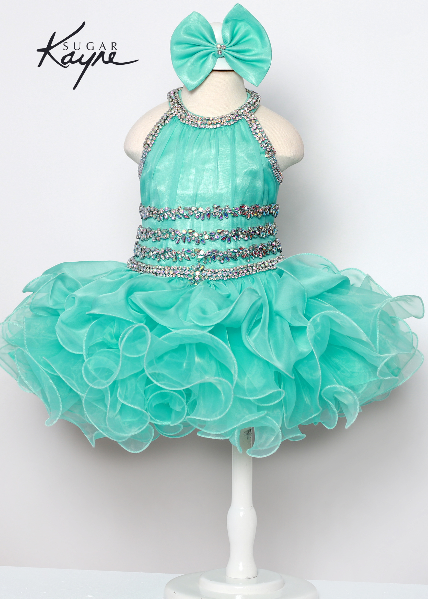 C216 Short girls Cupcake Ruffle High Neckline Pageant Dress Bow Crystal Embellished Have your little cupcake bring on all the charm in this stunning chiffon and organza gown. The corset back is the perfect addition as the little one grows! Colors: Aqua, Hot Coral Sizes: 0M, 12M, 18M, 24M, 2T, 3T, 4T, 5T, 6M, 6T Fabric Chiffon, Organza, Satin Lining