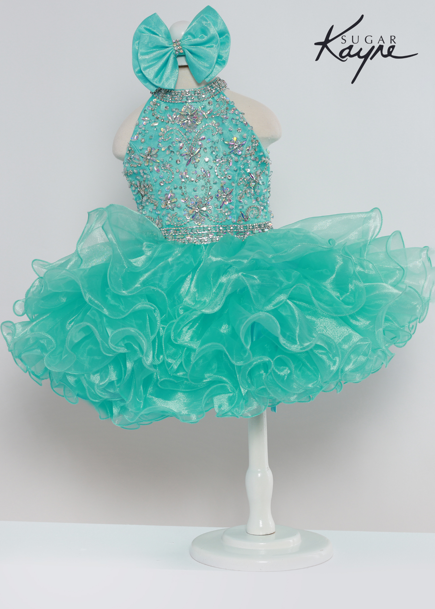 Sugar Kayne C223 Girls Baby Short ruffle Cupcake Pageant Dress Bow Halter Beaded Gown Have your little cupcake bring on all the charm in this stunning organza gown. The corset back is the perfect addition as the little one grows! Colors: Aqua, Petal Pink, Yellow Sizes: 0M, 12M, 18M, 24M, 2T, 3T, 4T, 5T, 6M, 6T Fabric Organza, Satin Lining