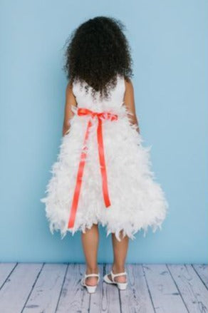 Rosebud Fashions Style 5120 is a T-length dress with a feather skirt and a satin top with a V neck in the back. The waist is accented with a ribbon that ties in the back with a flower. Satin buttons cover the zipper. Rosebuds Tea length flower girl dress feather skirt. Available Sizes: 2,4,6,8,10,12 Available Colors: Ivory, White Fabric is Satin and Feathers