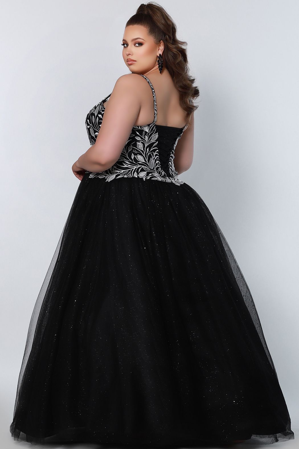 Sydney's Closet SC7329 This prom dress is full of romantic design details from the sweetheart neckline, white embroidered lace appliques, and lace-up back with modesty panel. A voluminous ball gown skirt completes the fairytale with layered tulle and glitter tulle. Available colors: Black, Platinum, Royal, Red Available sizes: 14-40