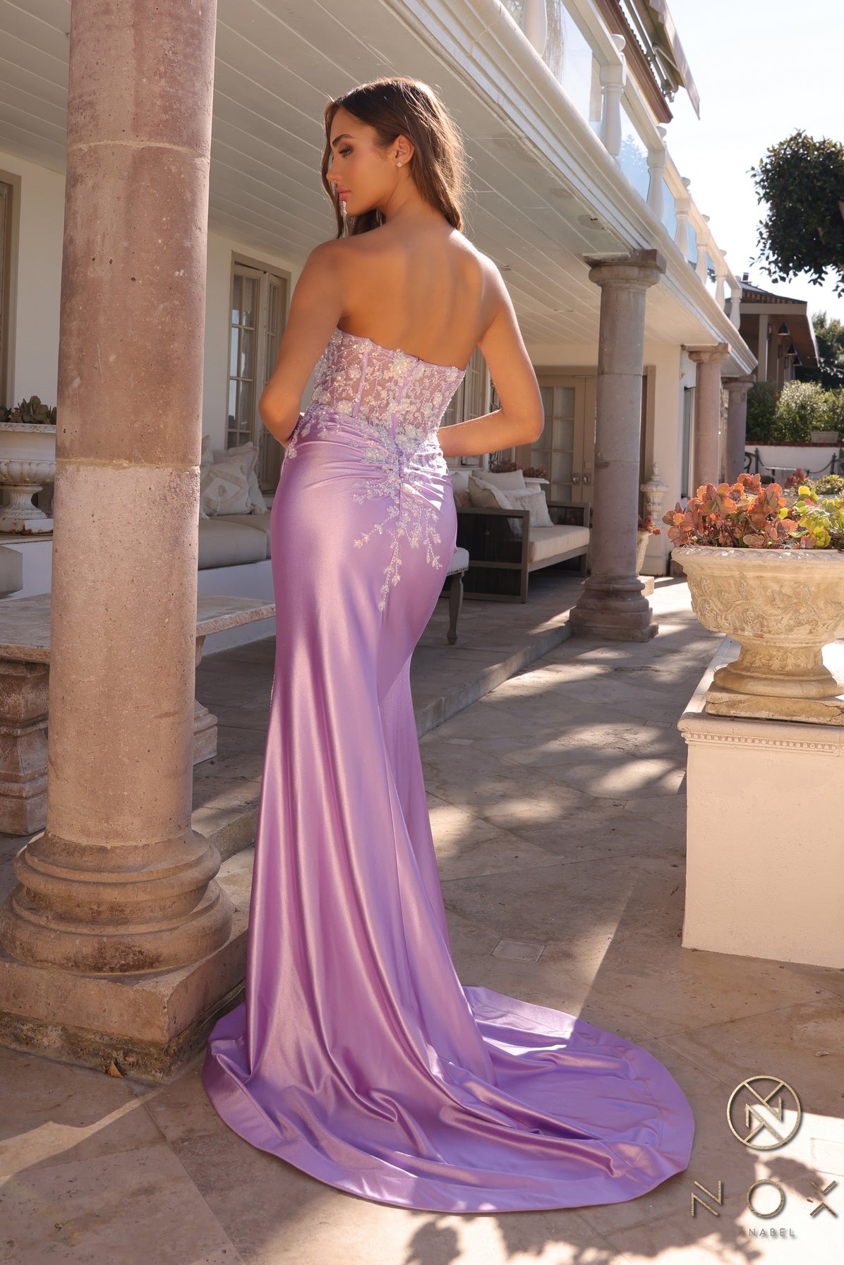 Get ready to turn heads in this stunning Nox Anabel C1346 dress! The sheer sequin detailing adds a touch of sparkle, while the strapless corset style enhances your figure. Made with luxurious satin, this maxi dress features a sultry slit for a formal yet sexy look. Perfect for prom or any special occasion.