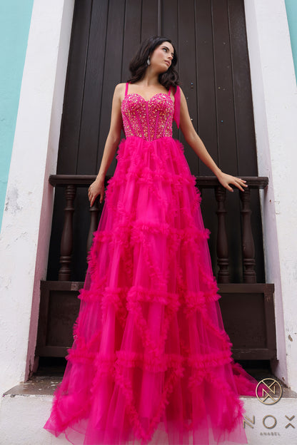 Get ready to stun in this gorgeous Nox Anabel T1340 Prom Dress. The ruffle tulle A-line design and corset bodice flatter every figure, while the sheer sequin details and bow pleated ballgown add a touch of glamour. Perfect for any formal event, this dress will make you feel confident and elegant all night long.  Sizes: 0-16  Colors: Blush, Fuchsia, Light Blue