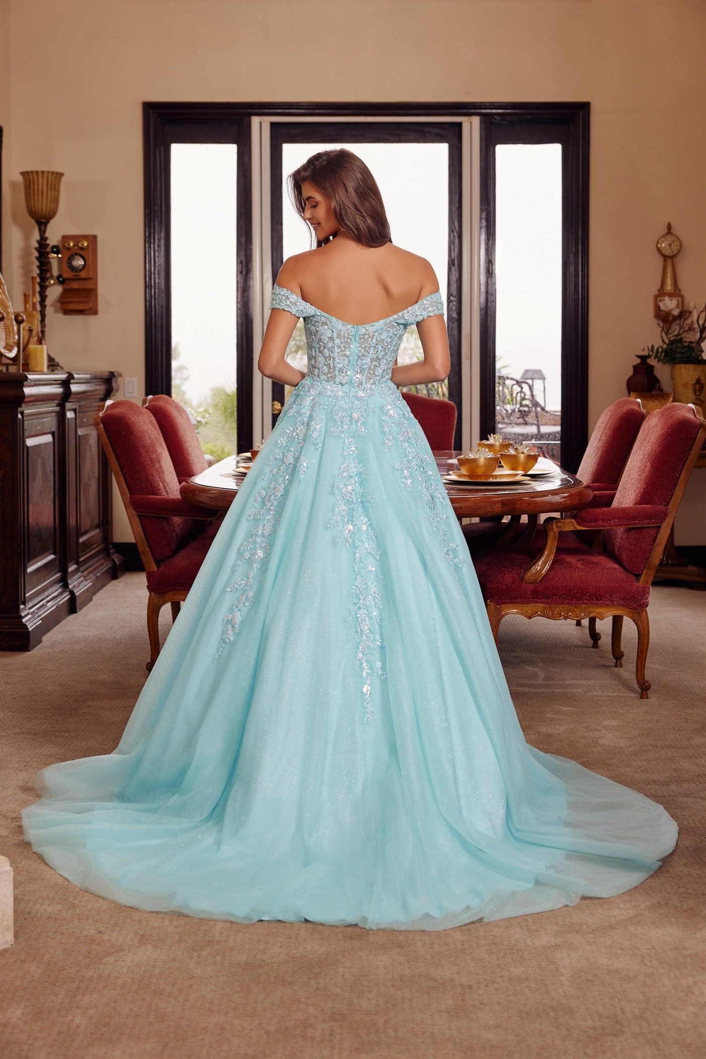 Nox Anabel's H1881 prom dress combines timeless elegance with contemporary allure. The off-the-shoulder silhouette frames the shoulders beautifully, while the sheer corset bodice creates a striking focal point with its plunging V-neckline. The flowing A-line skirt transitions into a graceful train, offering movement and drama on the dance floor. Crafted for those seeking a show-stopping entrance at prom or formal events, this dress balances sophistication with bold design details.

Sizes: 00-16

Colors: Aqu