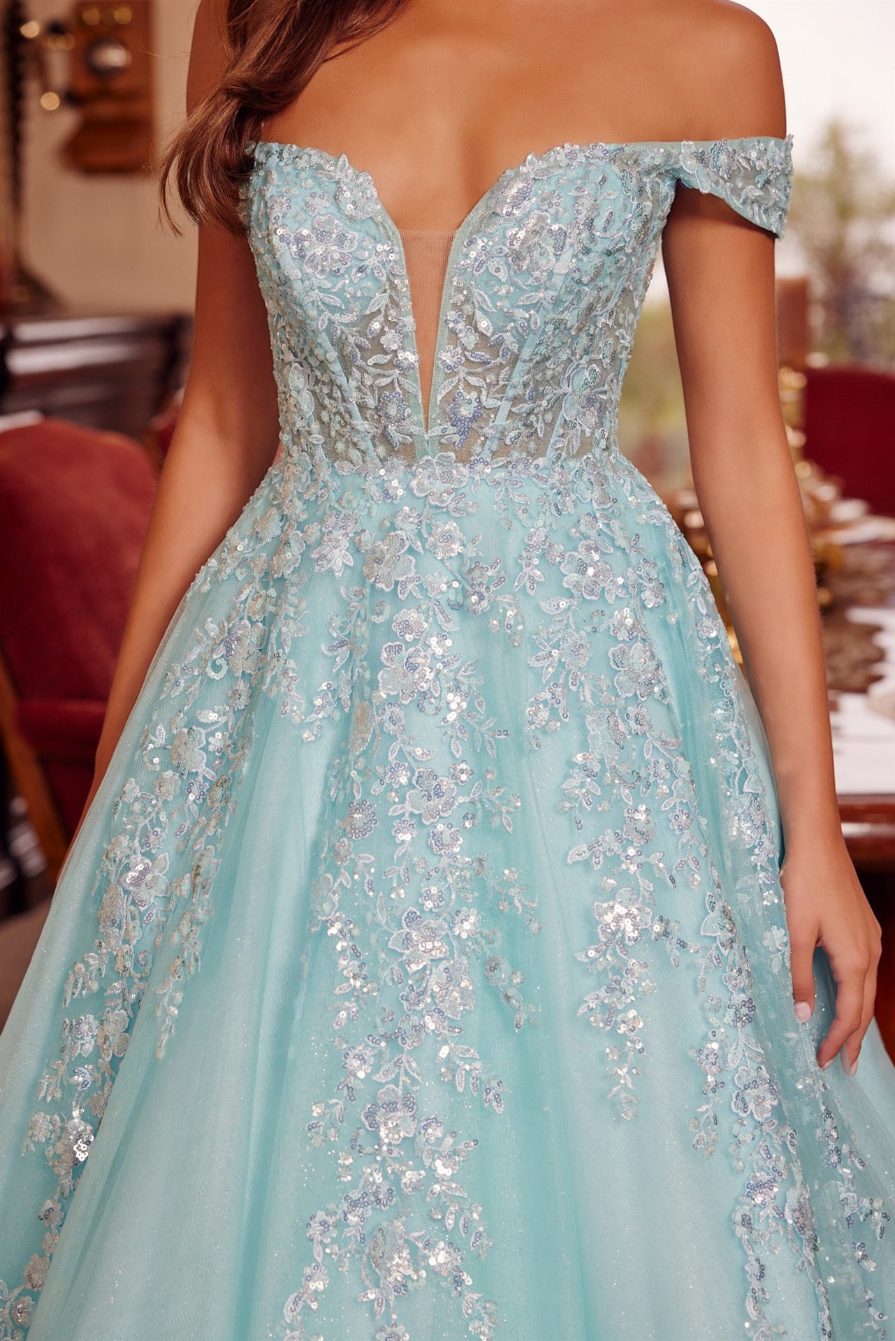 Nox Anabel's H1881 prom dress combines timeless elegance with contemporary allure. The off-the-shoulder silhouette frames the shoulders beautifully, while the sheer corset bodice creates a striking focal point with its plunging V-neckline. The flowing A-line skirt transitions into a graceful train, offering movement and drama on the dance floor. Crafted for those seeking a show-stopping entrance at prom or formal events, this dress balances sophistication with bold design details.

Sizes: 00-16

Colors: Aqu
