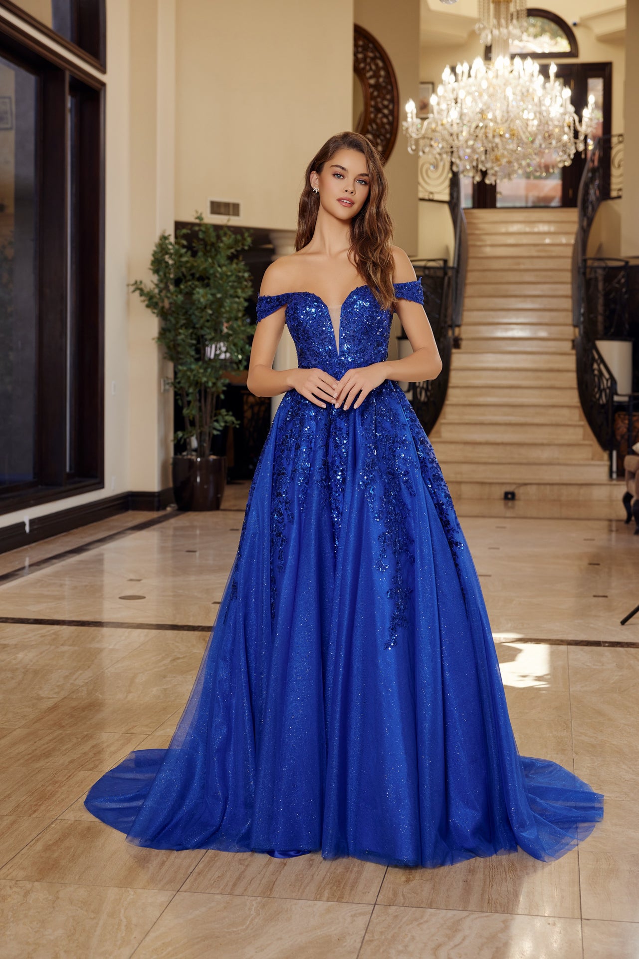 Nox Anabel's H1881 prom dress combines timeless elegance with contemporary allure. The off-the-shoulder silhouette frames the shoulders beautifully, while the sheer corset bodice creates a striking focal point with its plunging V-neckline. The flowing A-line skirt transitions into a graceful train, offering movement and drama on the dance floor. Crafted for those seeking a show-stopping entrance at prom or formal events, this dress balances sophistication with bold design details.

Sizes: 00-16

Colors: Aqu
