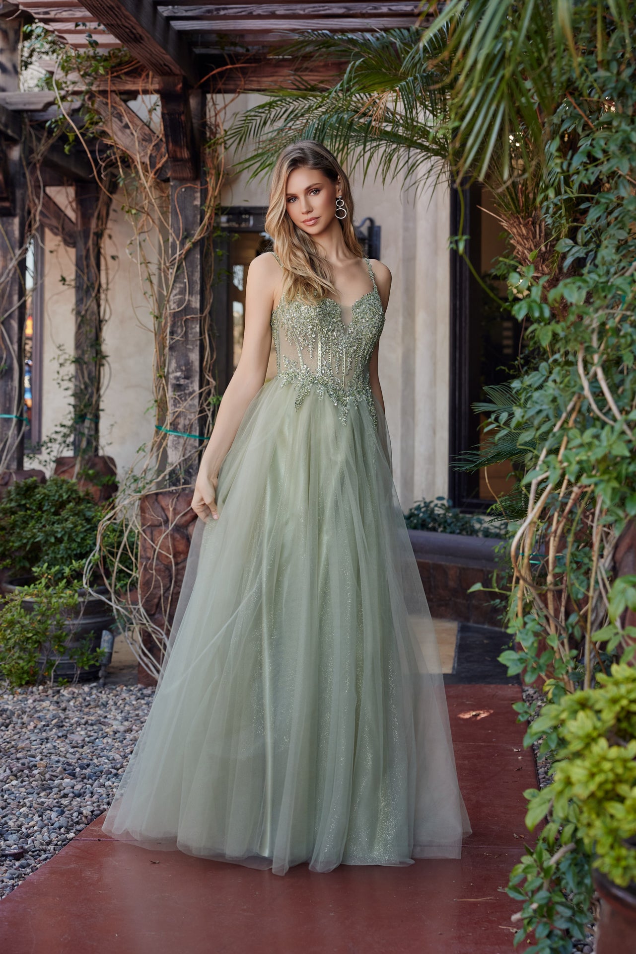 Make a statement in this Nox Anabel F1726 prom dress, featuring a sheer sequin corset bodice that catches the light with every movement. The structured A-line silhouette flatters your figure while the plunging V-neckline adds sophisticated allure. A graceful train completes the look with timeless elegance. Perfect for prom night or formal events where you want to feel confident and radiant.

Sizes: 00-16


Colors: Champagne, Greenery, Silver, Smoky Blue