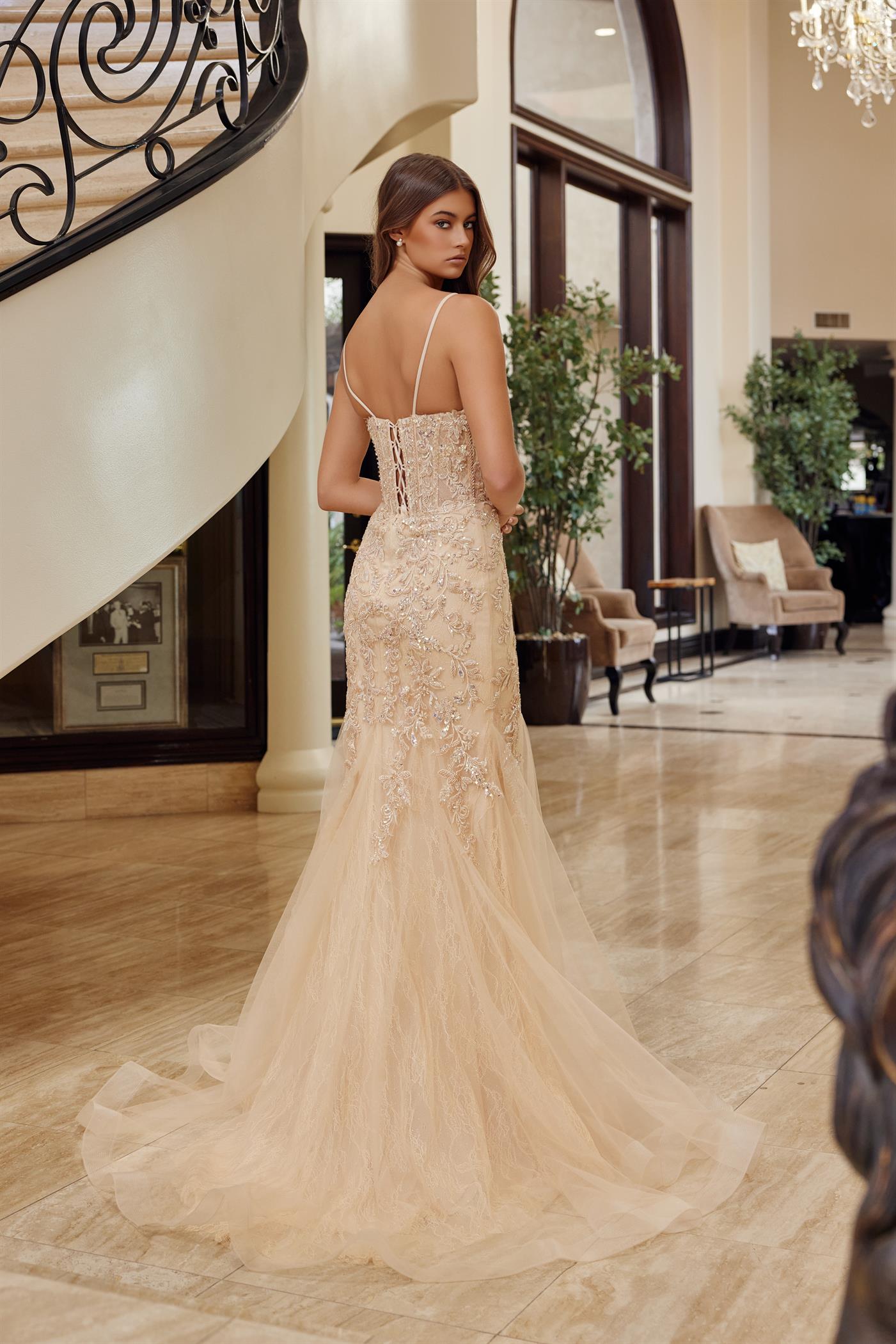 Nox Anabel's H1874 prom dress commands attention with its plunging sweetheart neckline and sheer sequin corset bodice. Delicate spaghetti straps frame the shoulders while the fitted mermaid silhouette flows into a dramatic train, creating an unforgettable entrance. Intricate sequin detailing catches light with every movement, perfect for those seeking a show-stopping formal look. Ideal for prom, pageants, or black-tie events where elegance meets glamour.

Sizes: 00-16

Colors: Blue, Champagne, Pink