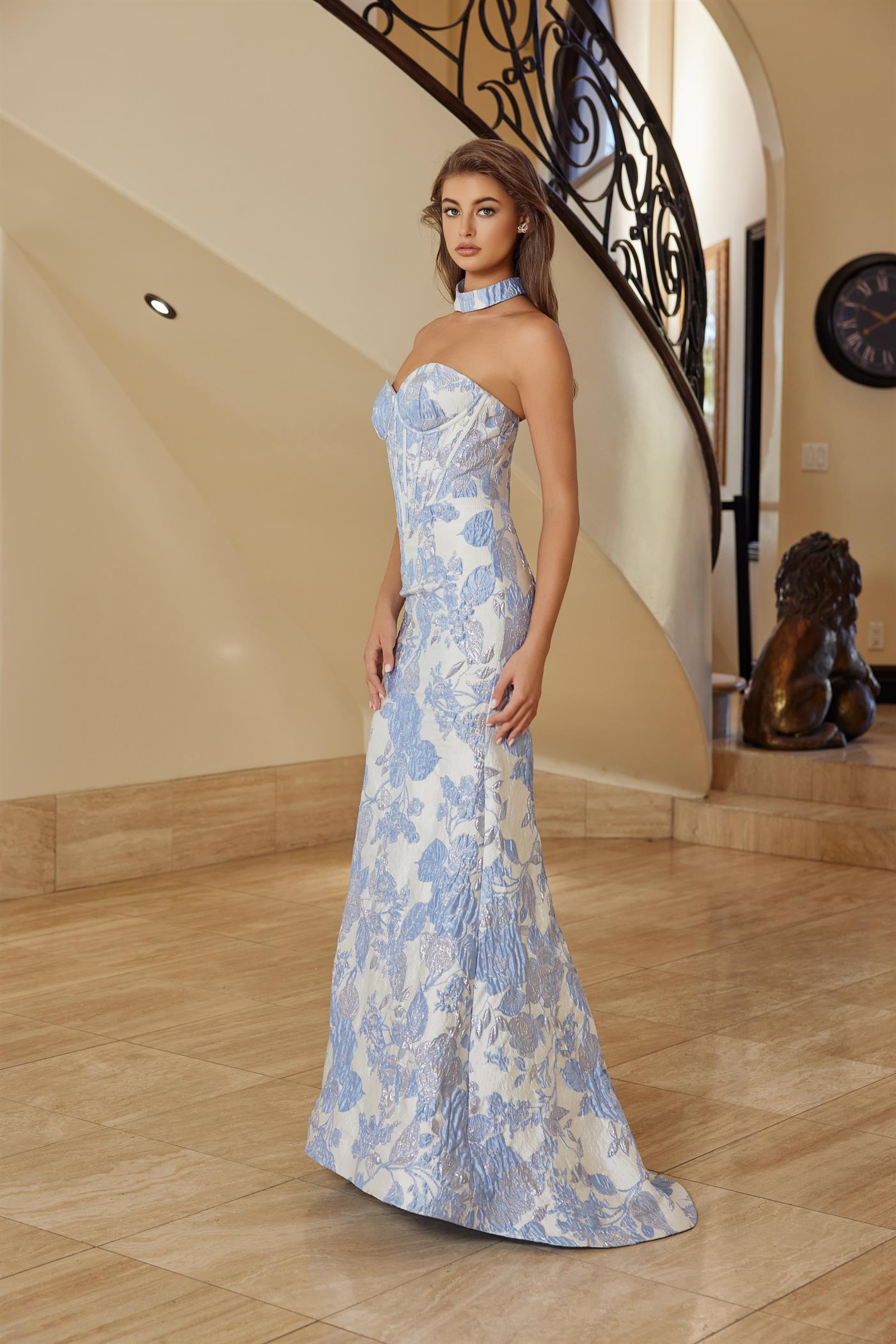 Nox Anabel's T1922 delivers editorial elegance for the modern prom-goer. This strapless sheath silhouette features a structured corset bodice that sculpts and supports, while the dramatic low back and choker train create an unforgettable entrance. The clean lines and refined construction make this dress equally at home on the red carpet or at formal events. A timeless investment piece for those who favor understated luxury and architectural design.

Sizes: 00-16

Colors: Blue, Pink
