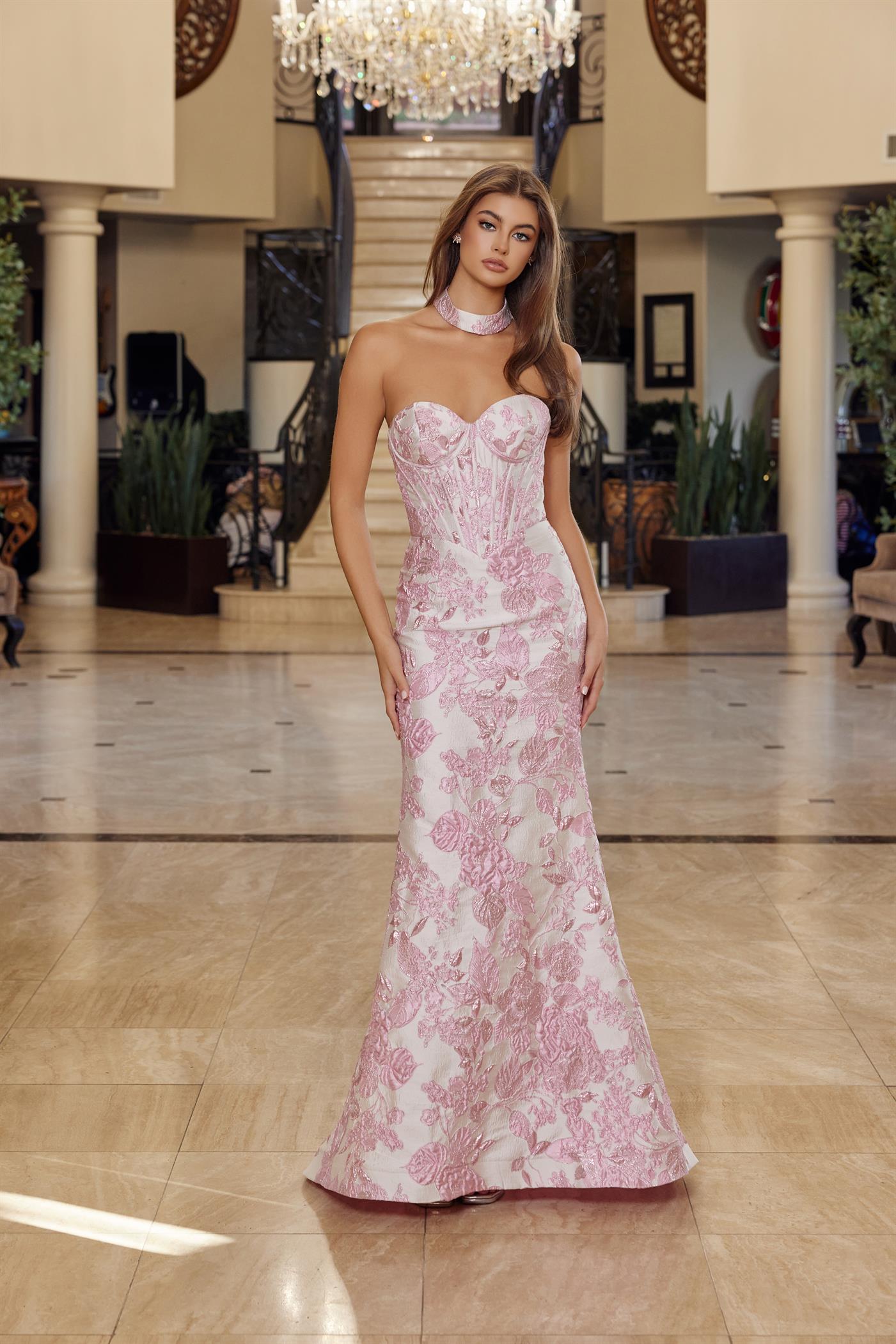 Nox Anabel's T1922 delivers editorial elegance for the modern prom-goer. This strapless sheath silhouette features a structured corset bodice that sculpts and supports, while the dramatic low back and choker train create an unforgettable entrance. The clean lines and refined construction make this dress equally at home on the red carpet or at formal events. A timeless investment piece for those who favor understated luxury and architectural design.

Sizes: 00-16

Colors: Blue, Pink