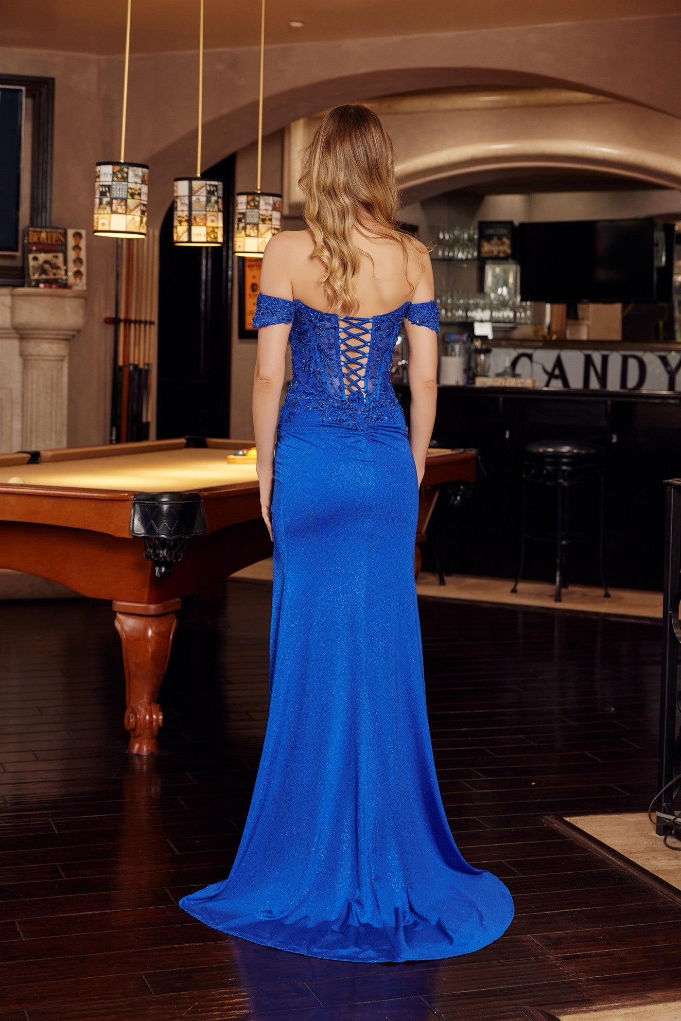 Nox Anabel's H1879 combines timeless elegance with modern glamour. This off-the-shoulder prom dress features a sheer sequin corset bodice that catches light with every movement, paired with a sweetheart neckline and dramatic low back for sophisticated allure. The flowing slit train adds movement and dimension to your silhouette. Perfect for prom, formal galas, or black-tie events where you want to make an unforgettable entrance.

Sizes: 00-16

Colors: Rose Gold, Royal Blue, Sage Green