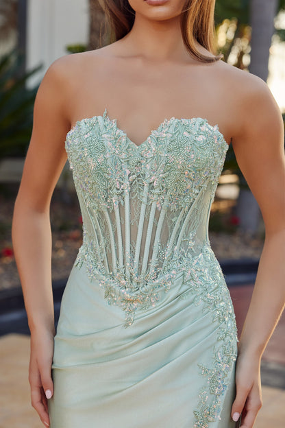 Elevate your prom night with the Nox Anabel R1811, a stunning strapless gown that commands attention. This sheer beaded corset bodice features intricate detailing that catches the light with every movement, while the sweetheart neckline flatters and frames beautifully. The low back design adds modern sophistication, and the dramatic slit train creates an elegant silhouette as you walk. Perfect for those seeking a show-stopping moment on the dance floor.

Sizes: 00-16

Colors: Mocha Gold, Sage Green