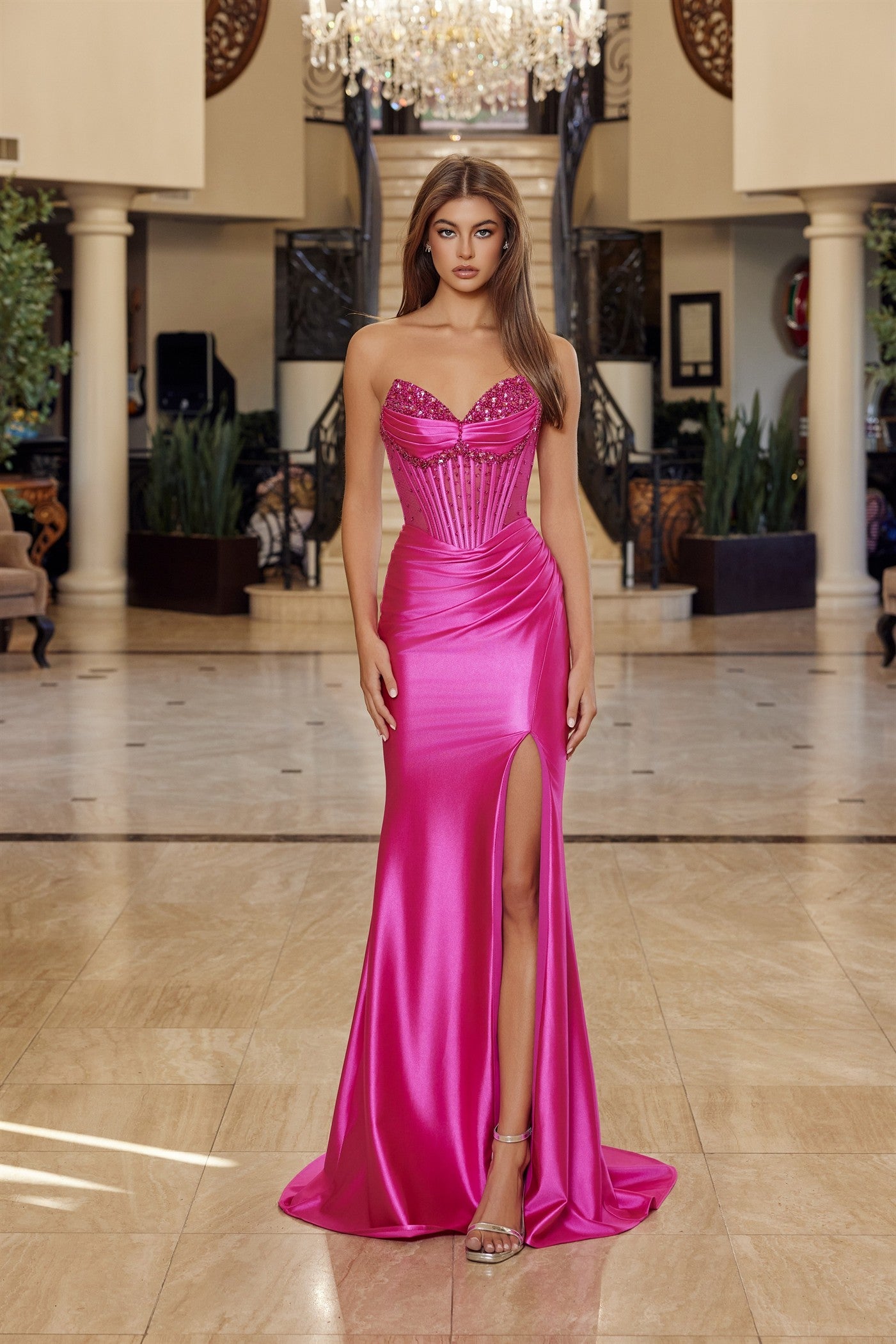 Elevate your prom night with the Nox Anabel R1812, a stunning strapless satin gown that commands attention. This sophisticated design features a sheer crystal-embellished corset bodice with a flattering V-neckline and pleated detailing that creates graceful movement. The luxurious satin skirt flows into a dramatic slit and sweeping train, while the backless silhouette adds an alluring touch of elegance. Perfect for those seeking a show-stopping formal look that balances glamour with refined style.

Sizes: 0