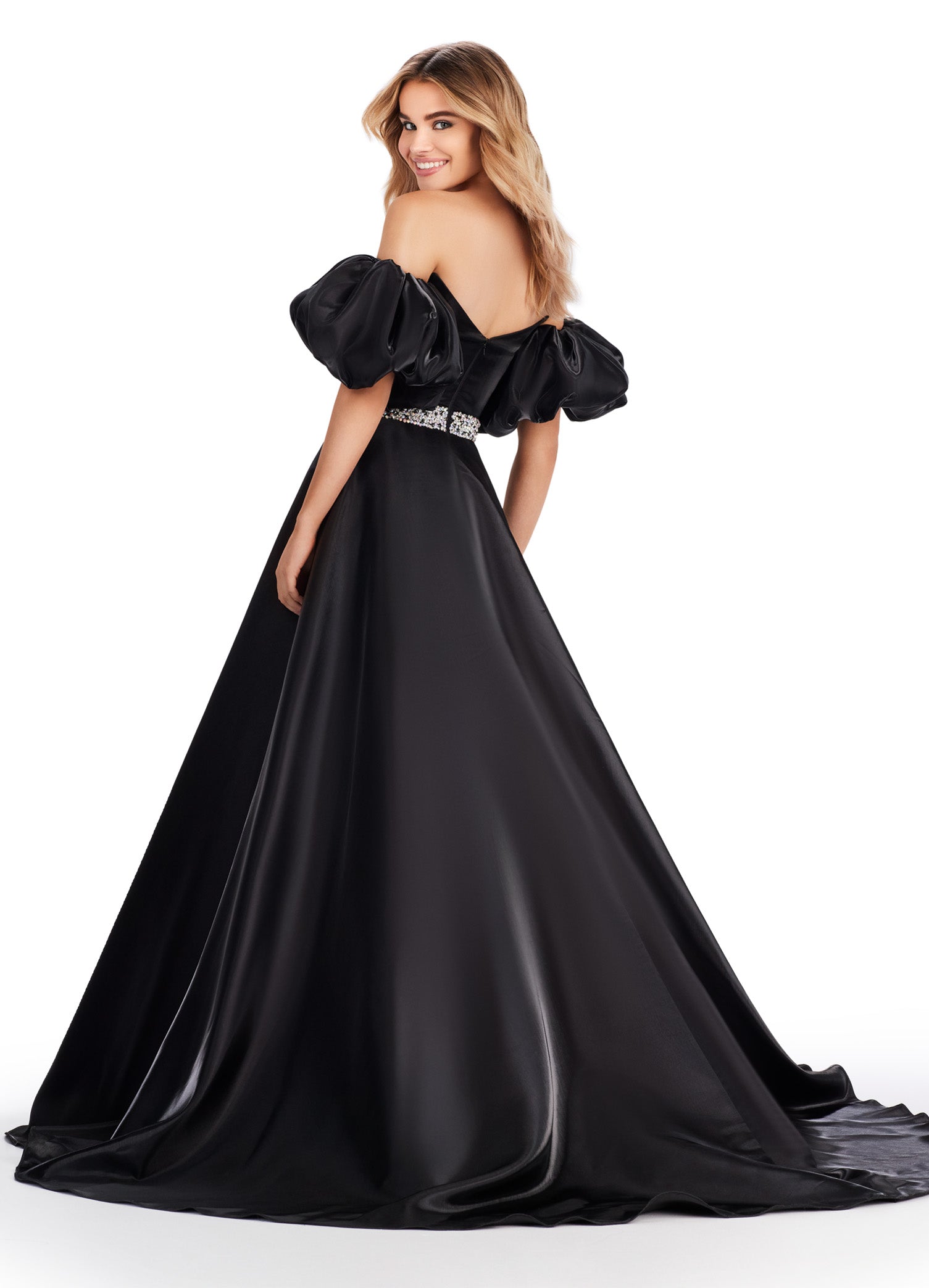 Elevate your formal look with the Ashley Lauren 11474 Long Prom Dress. This elegant strapless satin ball gown boasts a beaded belt, detachable puff sleeves, and a timeless pageant-style design. Perfect for making a statement at any event, this dress exudes sophistication and style. Be memorable in this strapless satin ball gown. This dress features a beaded belt detail, a left leg slit and detachable puff sleeves.