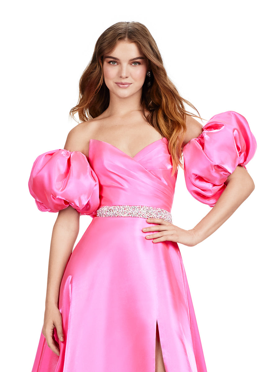 Elevate your formal look with the Ashley Lauren 11474 Long Prom Dress. This elegant strapless satin ball gown boasts a beaded belt, detachable puff sleeves, and a timeless pageant-style design. Perfect for making a statement at any event, this dress exudes sophistication and style. Be memorable in this strapless satin ball gown. This dress features a beaded belt detail, a left leg slit and detachable puff sleeves.