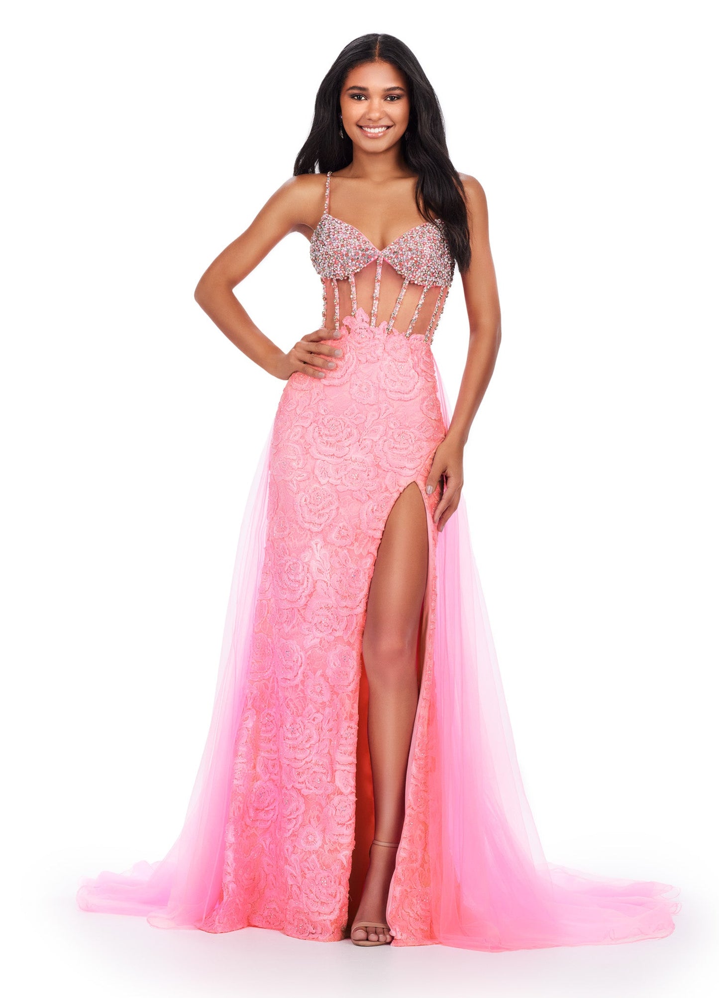 Be the star of the show in the Ashley Lauren 11517 Sheer Crystal Corset Lace Dress. Featuring a stunning corset lace bodice and sheer overskirt with a daring slit, this prom pageant gown is designed to make you stand out. Add a touch of glamour with crystal details and feel confident in this elegant and feminine dress. This romantic lace applique spaghetti strap gown features a beaded corset bustier. The look is completed a tulle overskirt.