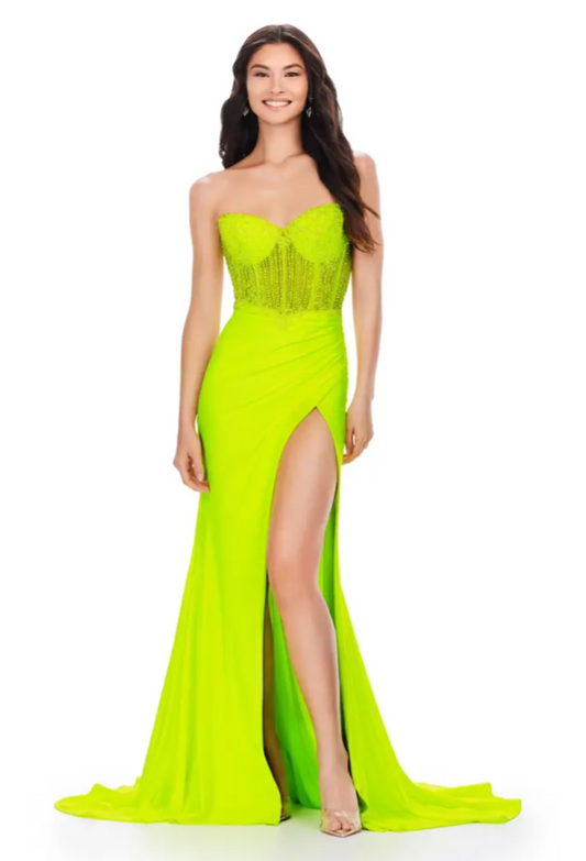 Ashley Lauren 11520 Long Fitted Jersey Maxi Slit Prom Dress Strapless Crystal Bodice This classic strapless jersey gown features a fully beaded corset bustier. The skirt features a left leg slit and ruched design.  Sizes: 00-24  Colors: Neon Green, Fuchsia, Royal, Coral  Sweetheart Neckline Beaded Bustier Lace Up Back Jersey Wrap Skirt