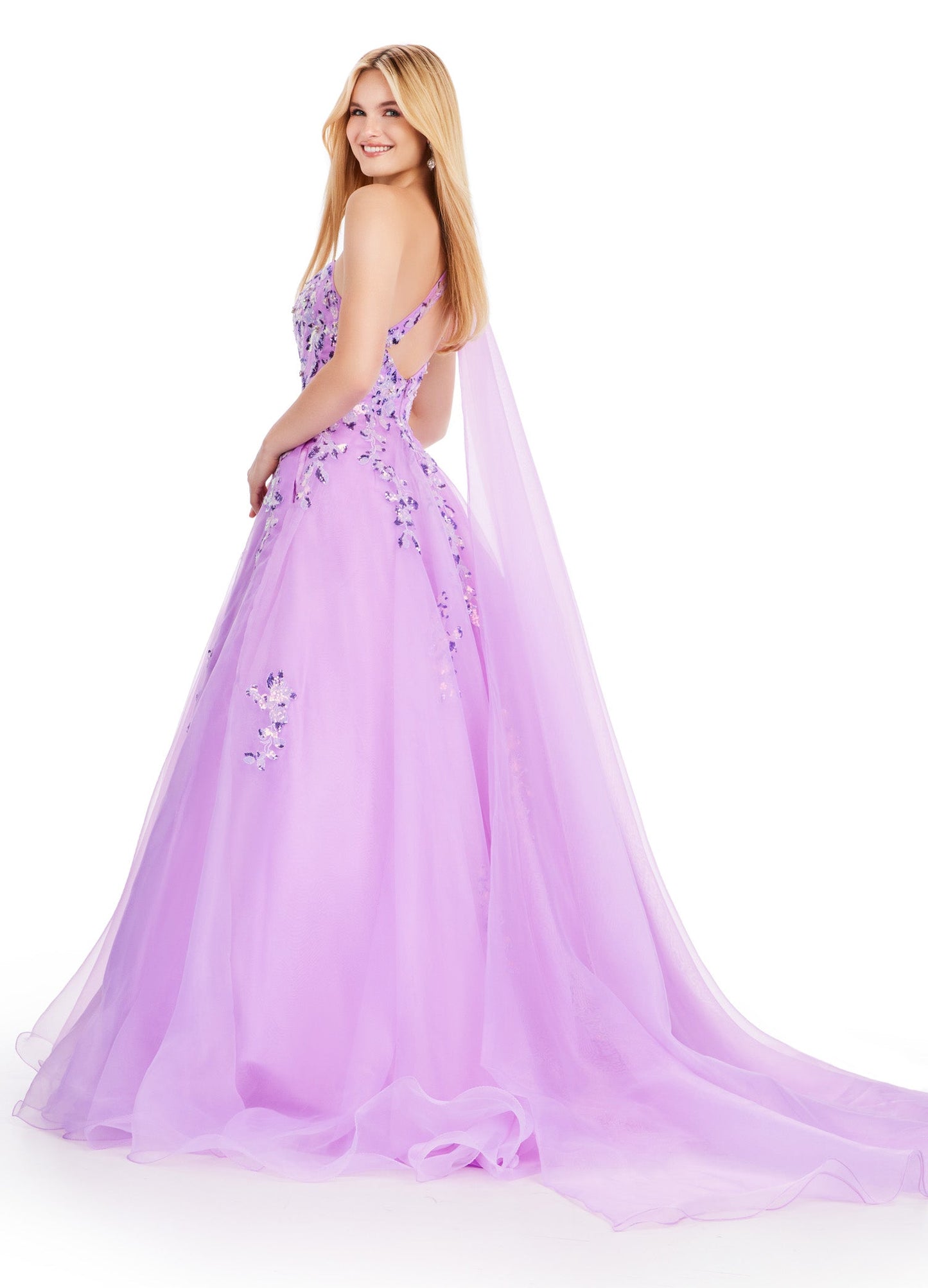 This Ashley Lauren 11573 Long Prom Dress exudes elegance with its one shoulder design and sequin applique. Crafted from high-quality organza, this gown will make you stand out at any formal event or pageant. Its classic silhouette and sparkling details are perfect for making a statement. This romantic one shoulder organza ball gown features intricate sequin applique. The look is complete with an open back and a one shoulder cape.