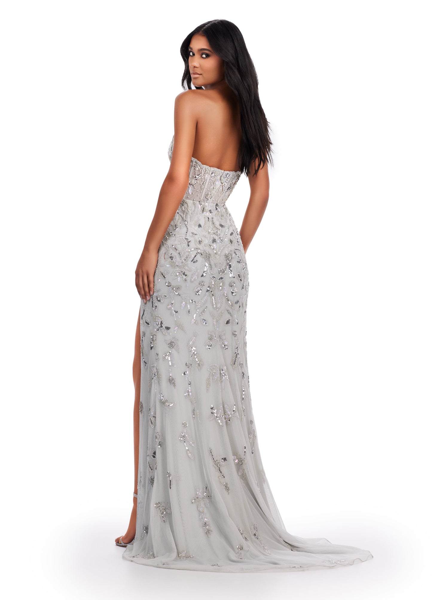 Achieve a stunning look with Ashley Lauren's 11614 Long Prom Dress. The beaded strapless gown features a corset bustier and a slit, adding a touch of elegance to its formal pageant style. Confidently stand out and make a statement at your special occasion. Feel like royalty in this elegant gown. This fully beaded design features an illusion corset bustier. The beading flows throughout the gown, which has a left leg slit.