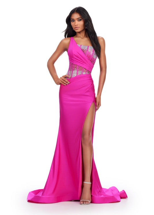 The Ashley Lauren 11617 Evening Gown is crafted from sheer fabric with a one shoulder design adorned with delicate crystal embroidery. The fitted silhouette features a corset bodice with a maxi slit and long train with a voluminous skirt. Perfect for prom, pageants, and formal events. Elegance with a twist! This one shoulder jersey gown features a stunning beaded corset bustier for an added touch of glam.  COLORS: Purple, Magenta, Peacock, Black Sizes: 00-24