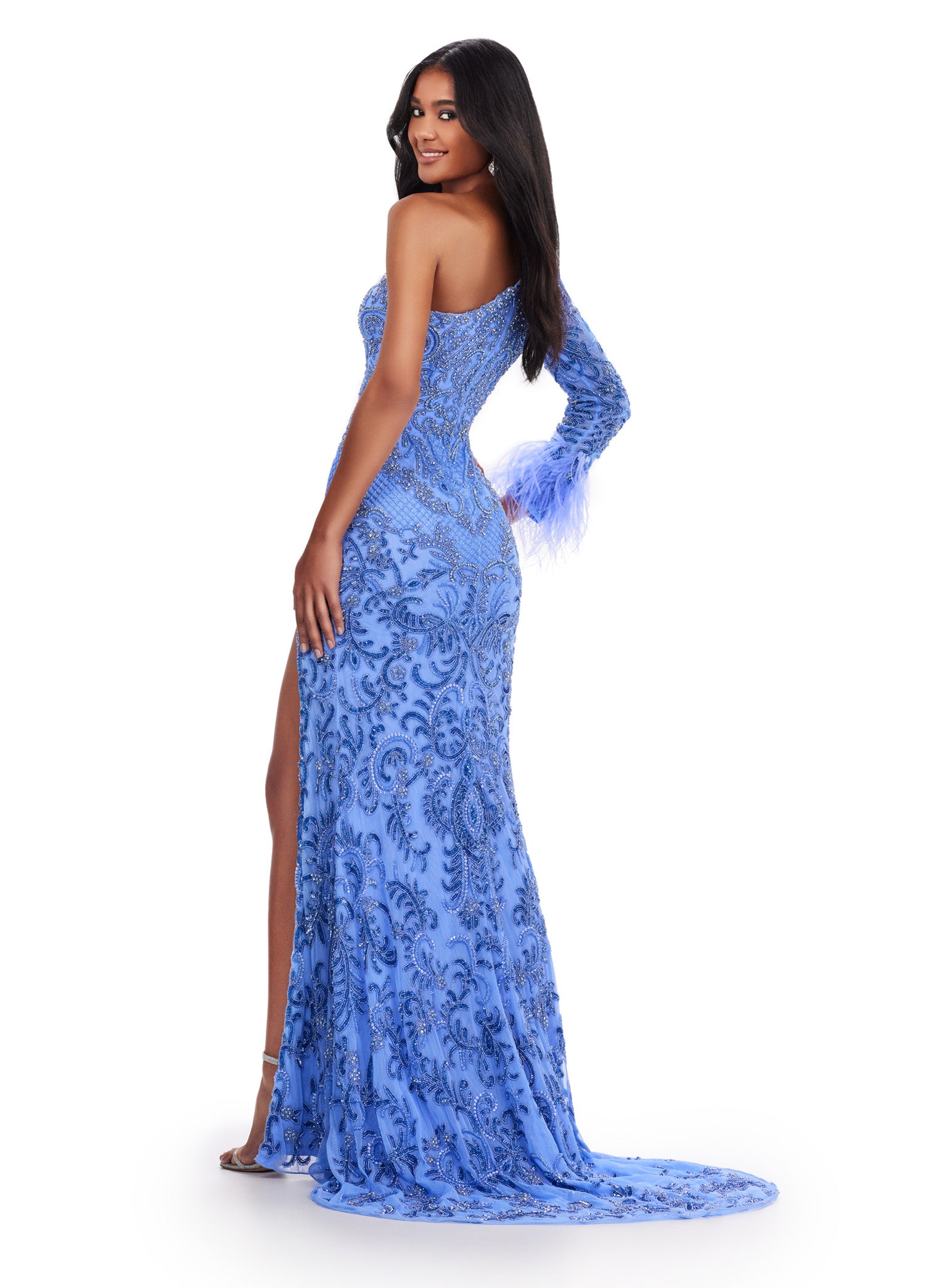 The Ashley Lauren 11649 Long Prom Dress is an elegant and unique choice for any formal occasion. The one shoulder design is complemented by a striking one sleeve cut out and intricate beaded detailing. The feather cuff adds a touch of glamour to this stunning pageant gown. Make an entrance in this fully beaded gown. This intricately beaded one shoulder gown is accented by side cut out and feather cuff sleeve. The look is complete with a sweep train and left leg slit.